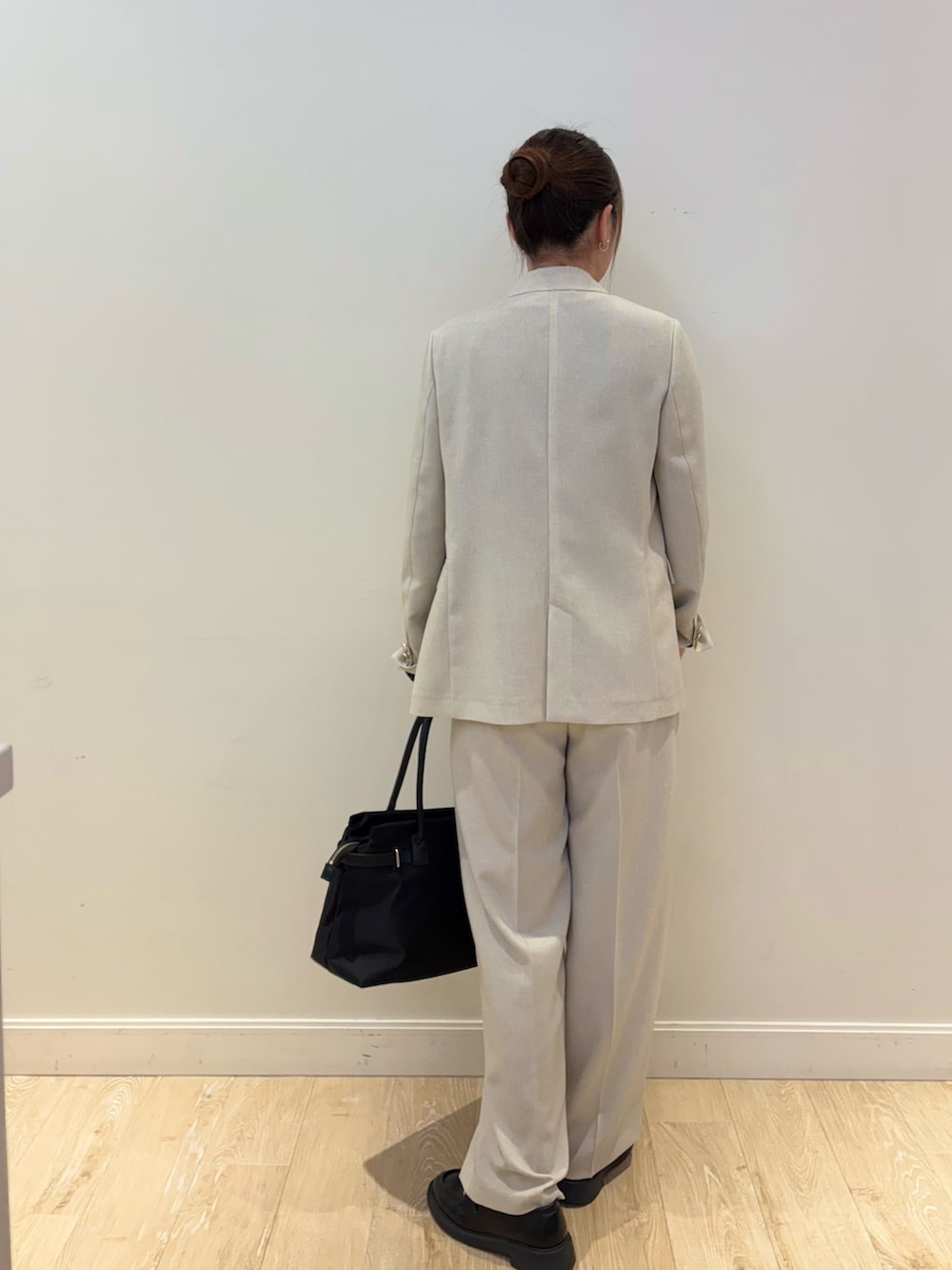 ブラック系のトートバッグ、ブラック系のTシャツ/カットソー、ベージュ系のテーラードジャケットを着用したレディースの春コーディネートの3枚目の写真