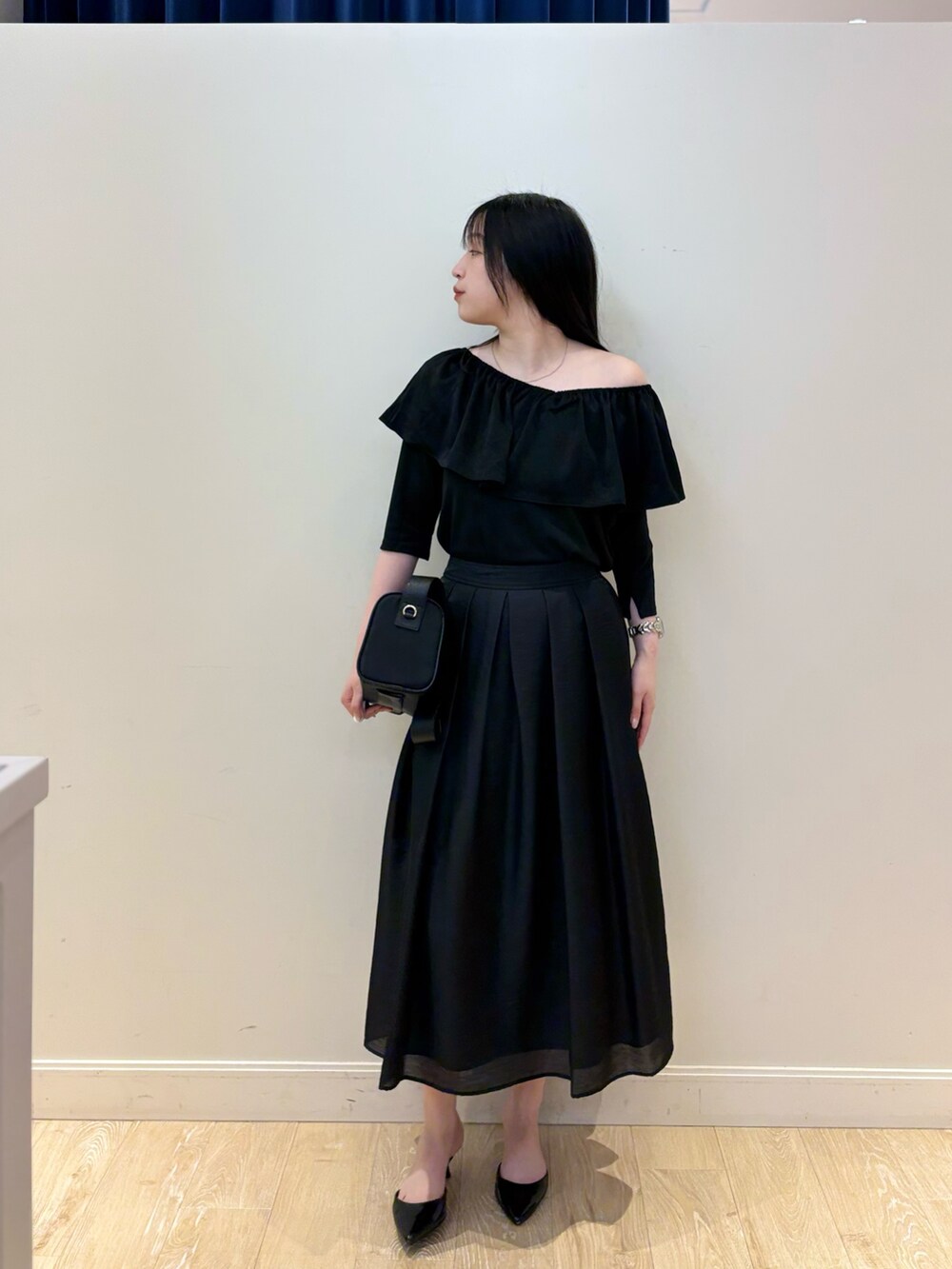 ブラック系のショルダーバッグ、ブラック系のTシャツ/カットソー、ブラック系のスカートを着用したレディースの夏コーディネートの3枚目の写真