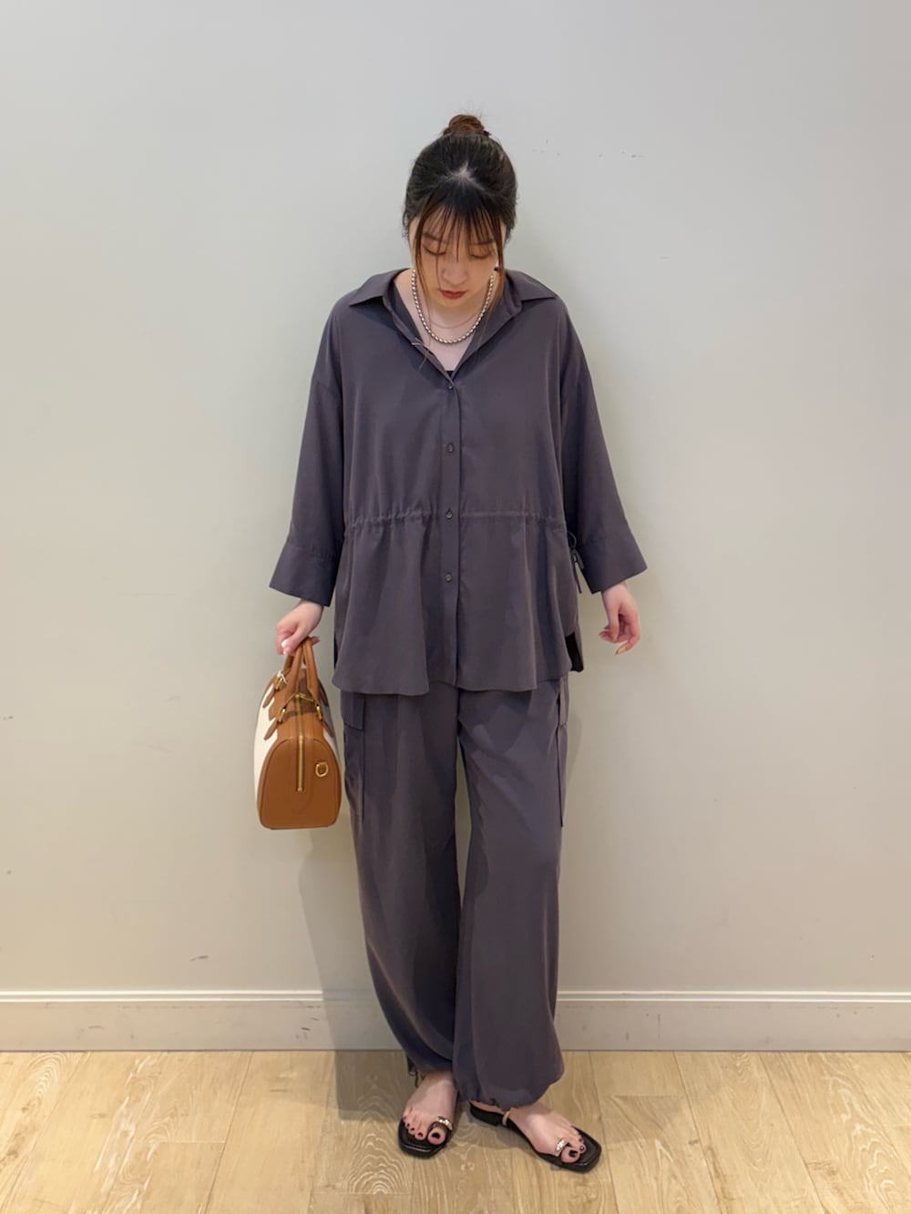 ブラウン系のボストンバッグ、グレー系のカーゴパンツ、グレー系のシャツ/ブラウスを着用したレディースの春コーディネートの4枚目の写真
