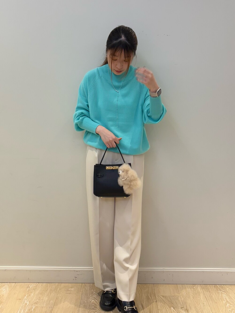 ブラック系のショルダーバッグ、ホワイト系のその他パンツ、グリーン系のニット/セーターを着用したレディースの秋コーディネートの4枚目の写真