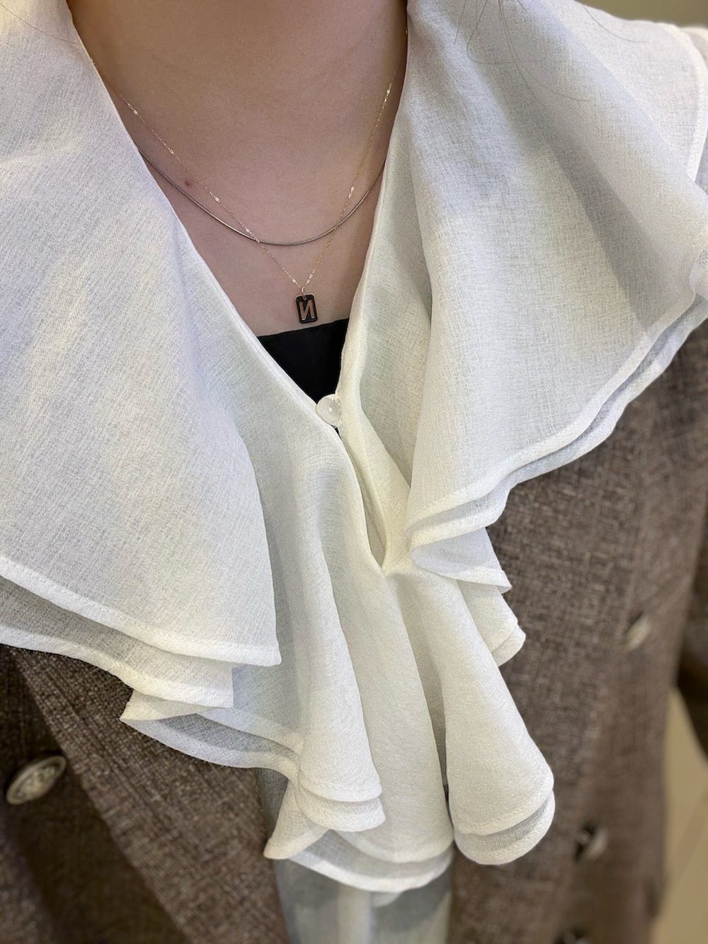 ブラック系のタンクトップ、ブルー系のテーラードジャケット、ブラック系のトートバッグを着用したレディースの冬コーディネートの5枚目の写真