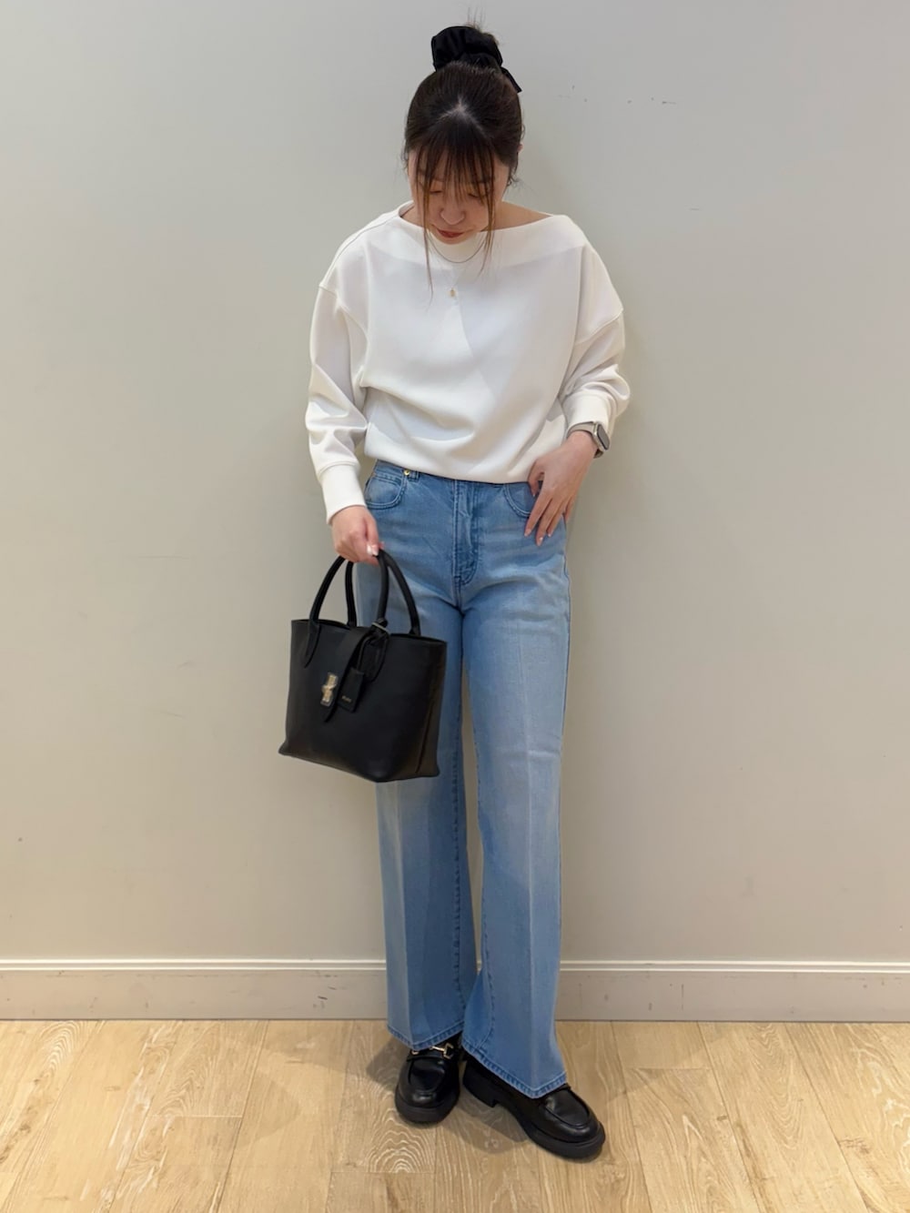 ブラック系のトートバッグ、ブルー系のデニムパンツ、ホワイト系のTシャツ/カットソーを着用したレディースの冬コーディネートの3枚目の写真