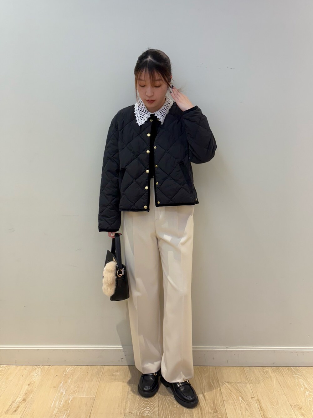 ブラック系のニット/セーター、ホワイト系のその他パンツ、ブラック系のショルダーバッグを着用したレディースの秋コーディネートの3枚目の写真