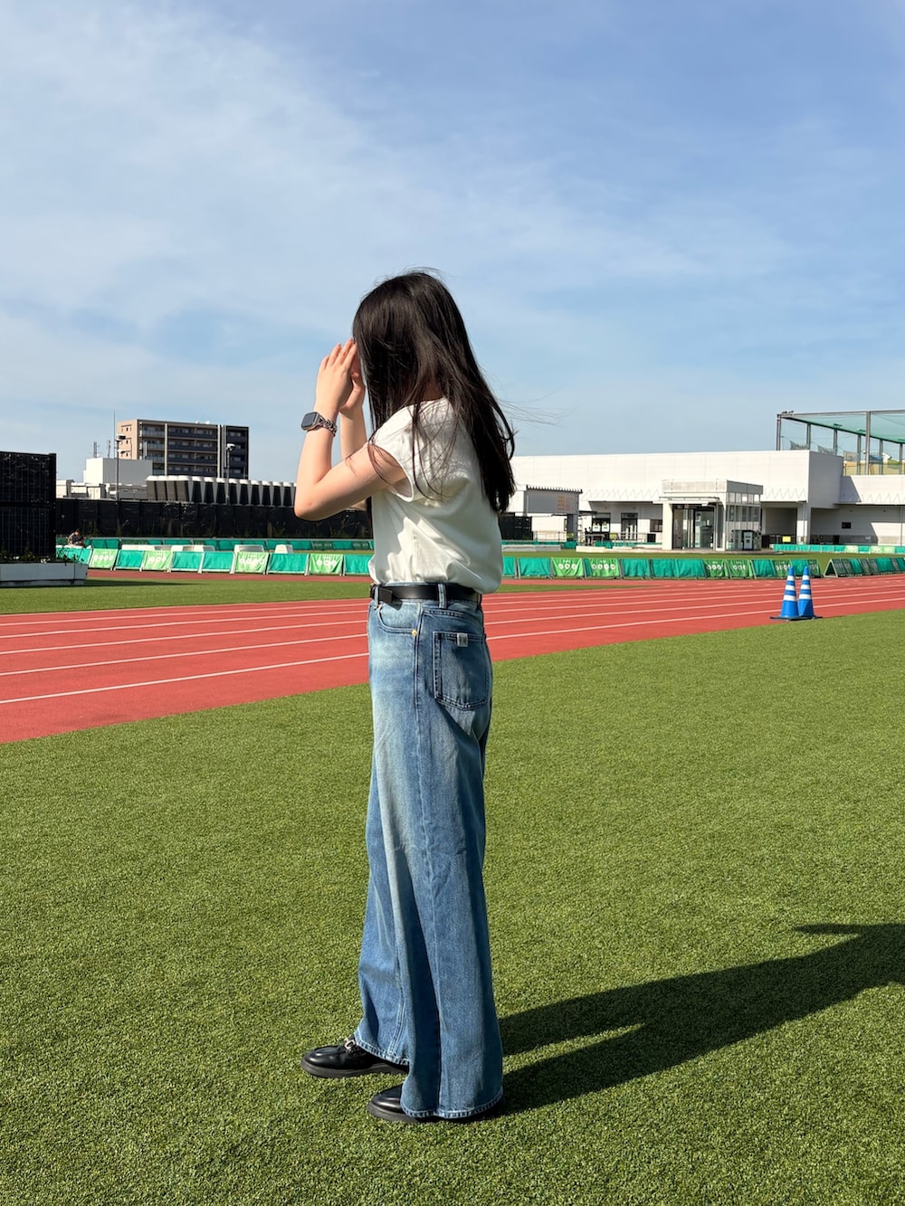 ホワイト系のTシャツ/カットソー、ブルー系のデニムパンツ、ブラック系のベルトを着用したレディースの夏コーディネートの2枚目の写真