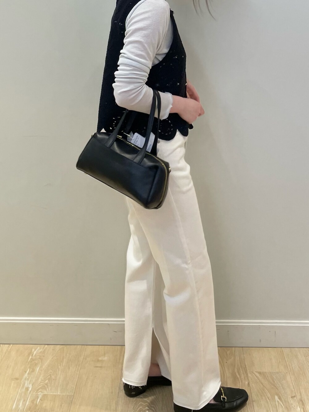 ホワイト系のデニムパンツ、ブラック系のベスト、シルバー系のTシャツ/カットソーを着用したレディースの冬コーディネートの2枚目の写真