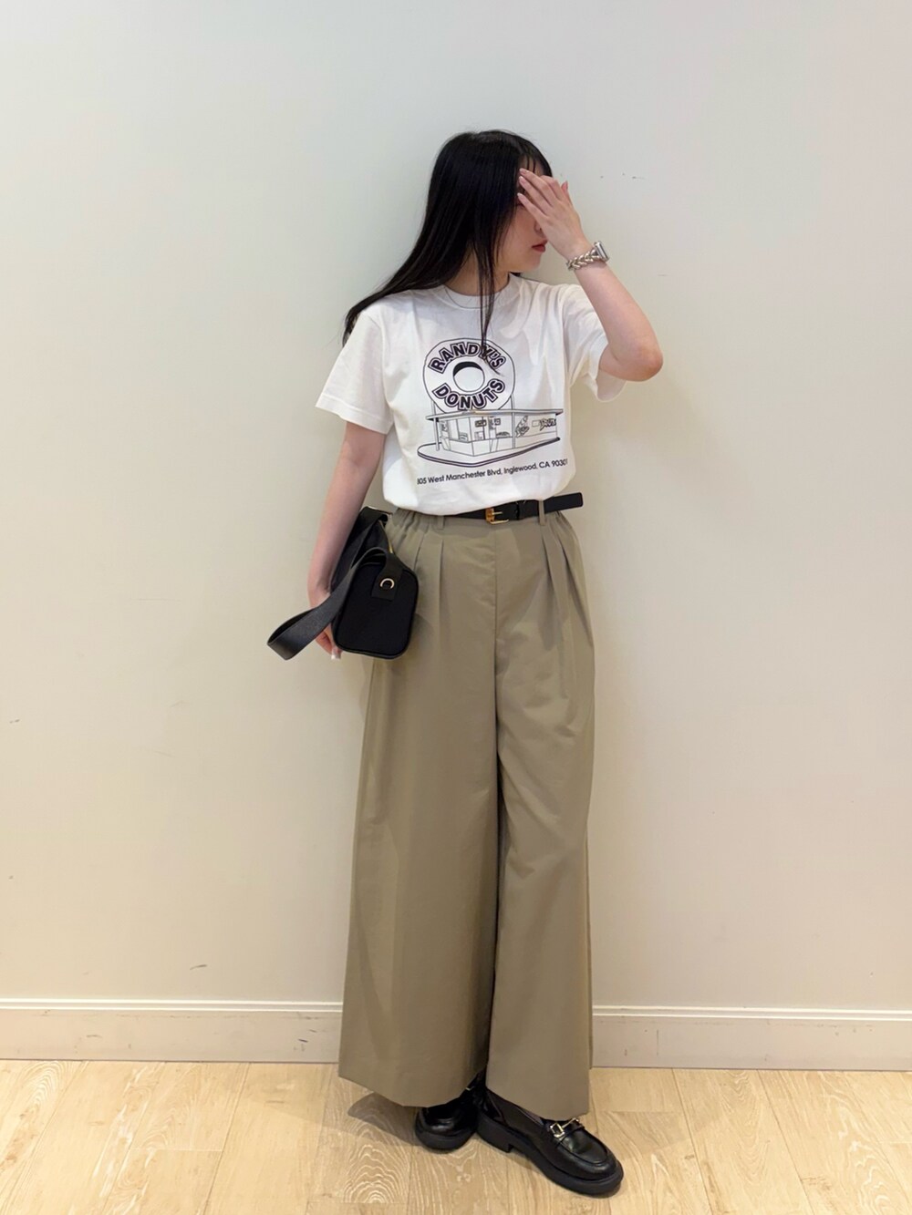 ブラック系のショルダーバッグ、ホワイト系のTシャツ/カットソー、ベージュ系のその他パンツを着用したレディースの夏コーディネートの4枚目の写真