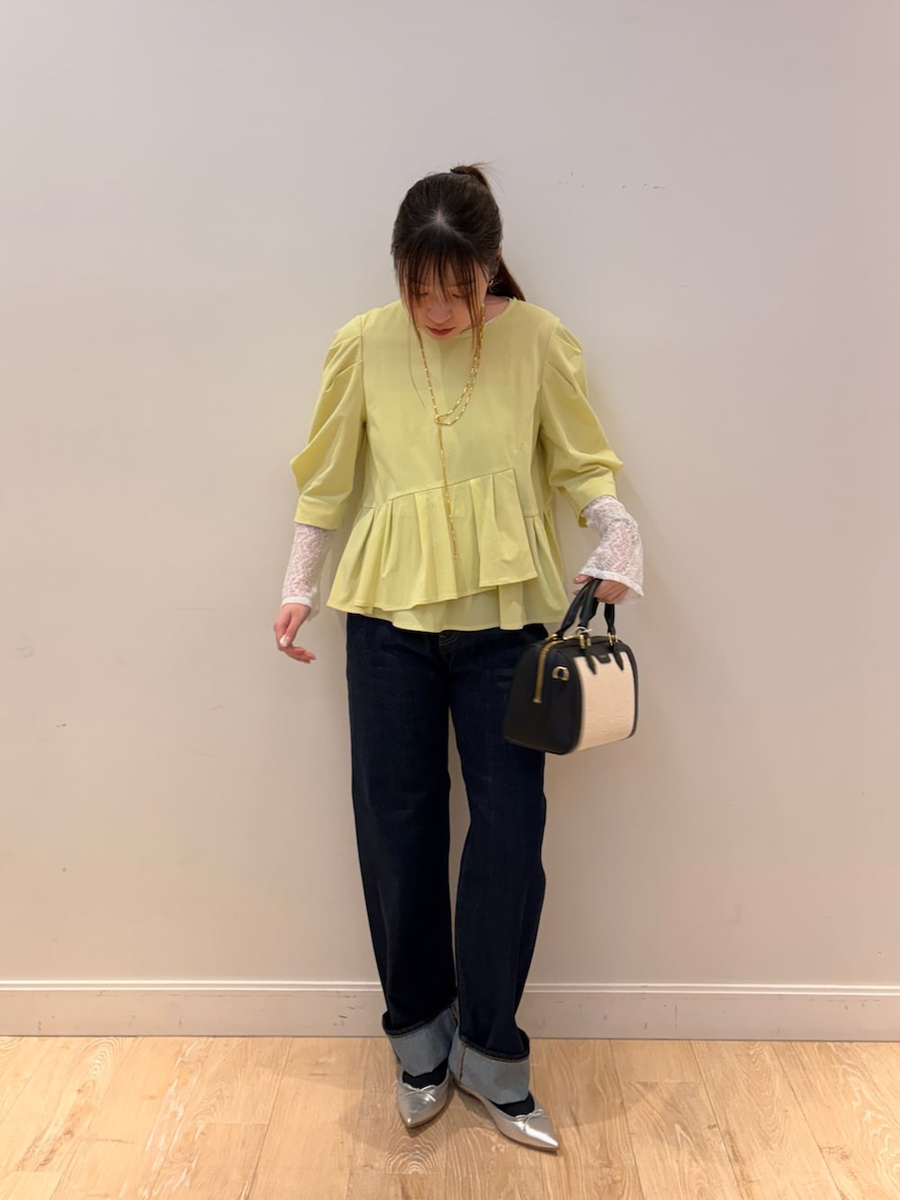 ブラック系のTシャツ/カットソー、ブラック系のボストンバッグ、ブルー系のデニムパンツを着用したレディースの春コーディネートの3枚目の写真