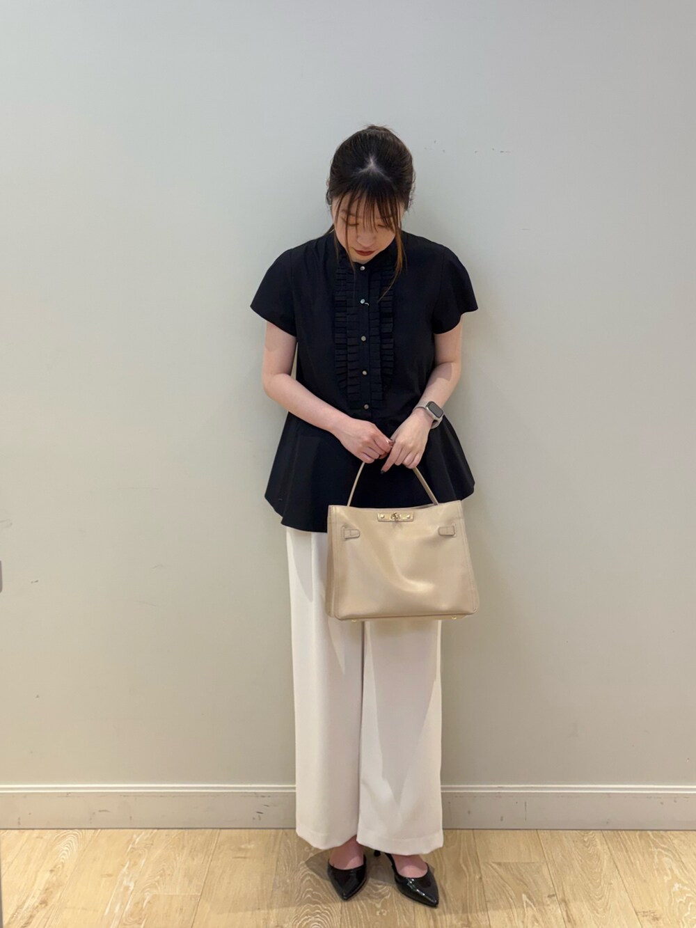 ベージュ系のトートバッグ、ホワイト系のその他パンツ、ブラック系のシャツ/ブラウスを着用したレディースの春コーディネートの4枚目の写真