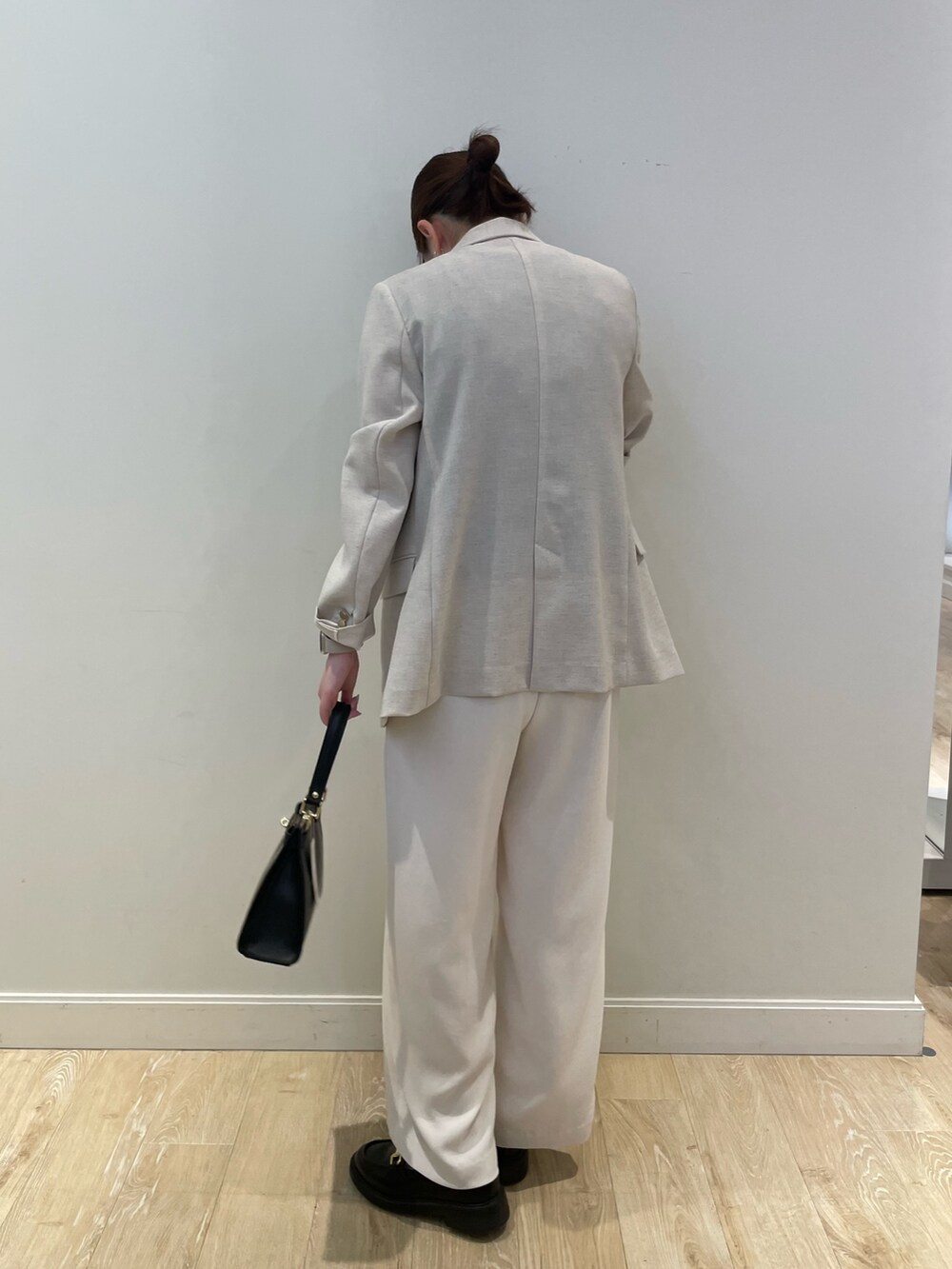 ブラック系のショルダーバッグ、ホワイト系のその他パンツ、ベージュ系のテーラードジャケットを着用したレディースの春コーディネートの3枚目の写真