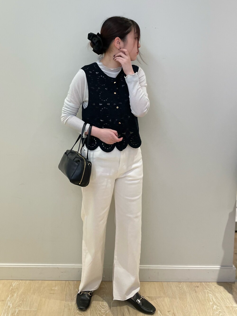 ホワイト系のデニムパンツ、ブラック系のベスト、シルバー系のTシャツ/カットソーを着用したレディースの冬コーディネートの4枚目の写真