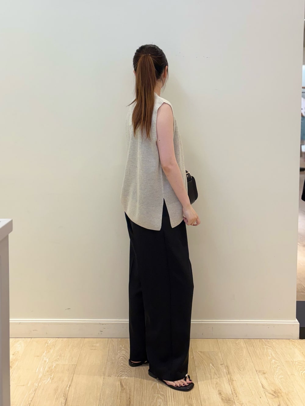 ブラック系のタンクトップ、ブラック系のその他パンツ、ベージュ系のニット/セーターを着用したレディースの夏コーディネートの2枚目の写真