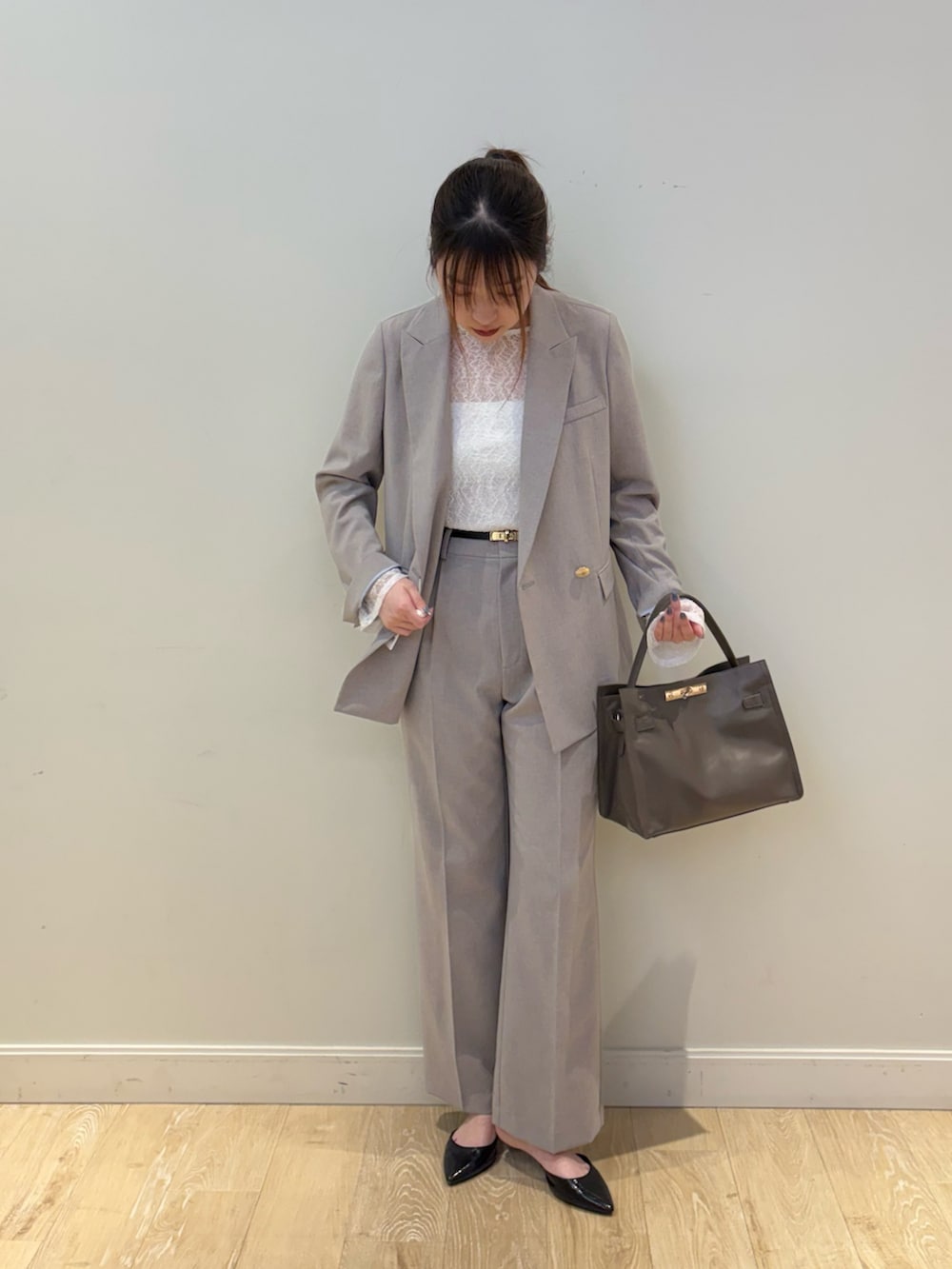 ベージュ系のトートバッグ、グレー系のテーラードジャケット、ブラック系のTシャツ/カットソーを着用したレディースの春コーディネートの3枚目の写真