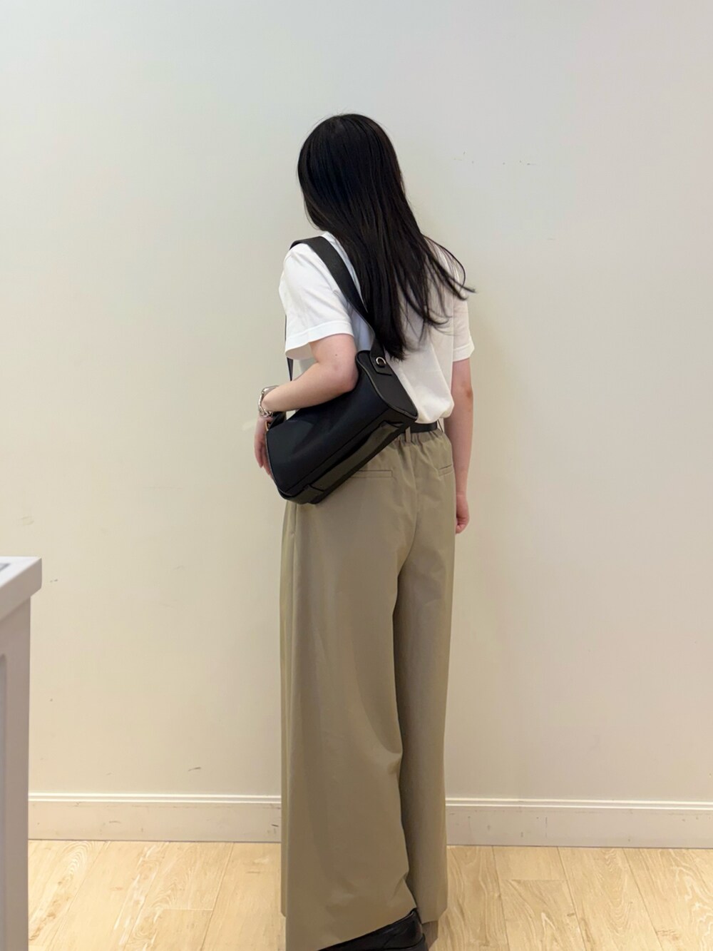 ブラック系のショルダーバッグ、ホワイト系のTシャツ/カットソー、ベージュ系のその他パンツを着用したレディースの夏コーディネートの3枚目の写真
