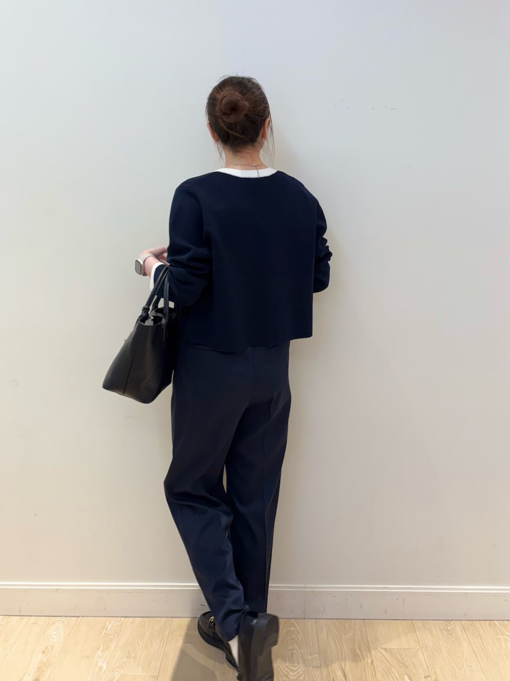 ブラック系のトートバッグ、ホワイト系のタンクトップ、ブルー系のカーディガン/ボレロを着用したレディースの春コーディネートの2枚目の写真