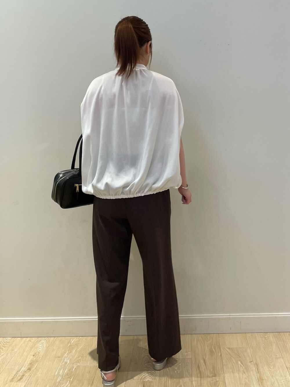 ブラウン系のその他パンツ、ブラック系のボストンバッグ、ホワイト系のシャツ/ブラウスを着用したレディースの夏コーディネートの3枚目の写真