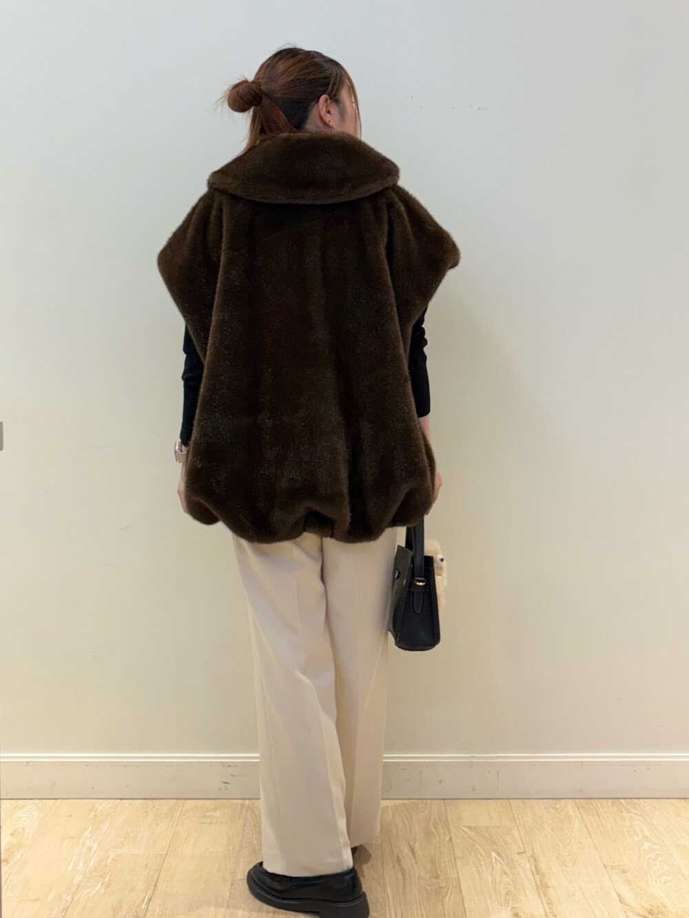 ブラック系のニット/セーター、ブラック系のショルダーバッグ、ホワイト系のその他パンツを着用したレディースの秋コーディネートの2枚目の写真