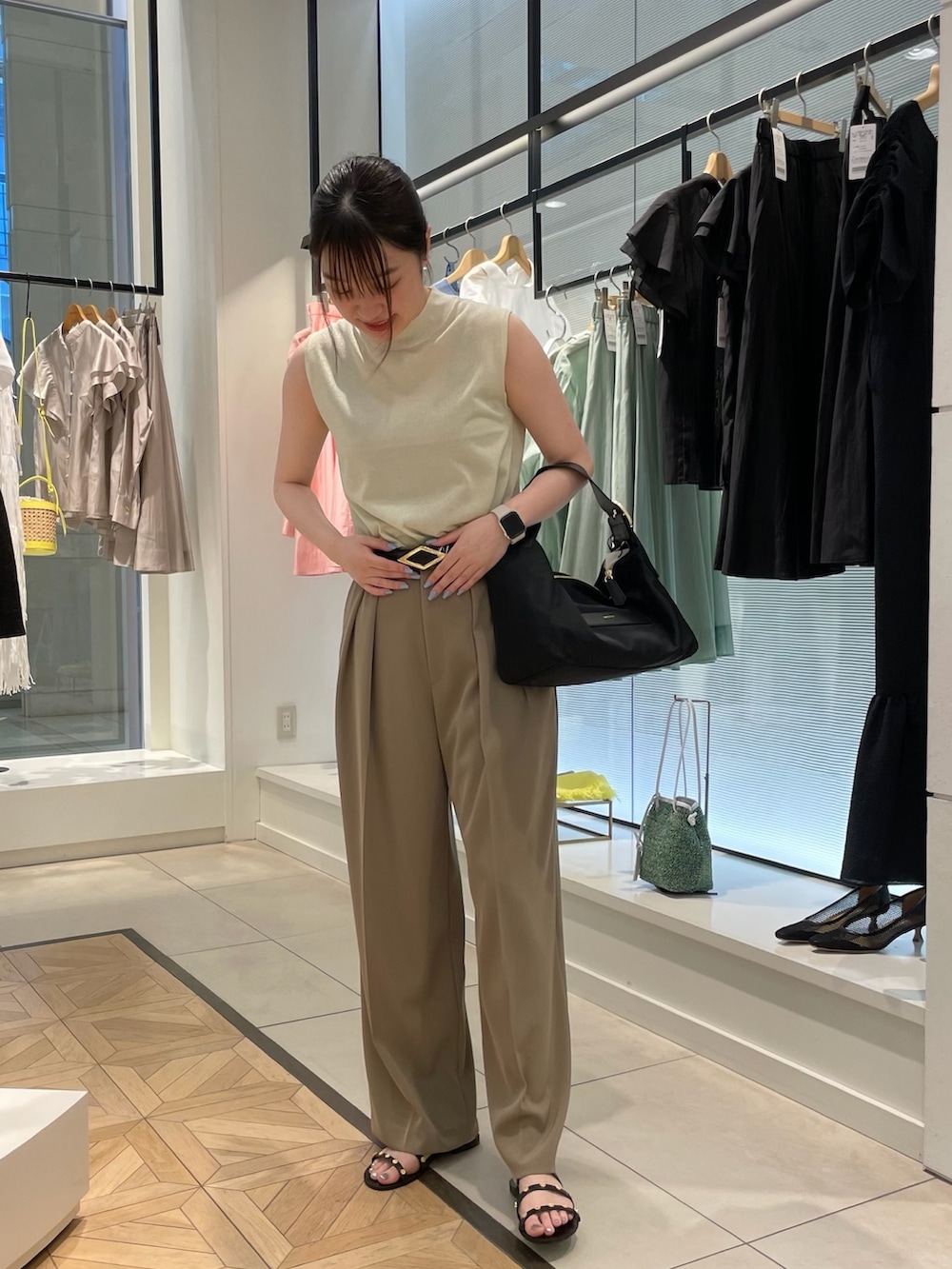 ゴールド系のニット/セーター、グリーン系のその他パンツ、ブラック系のショルダーバッグを着用したレディースの春コーディネートの2枚目の写真