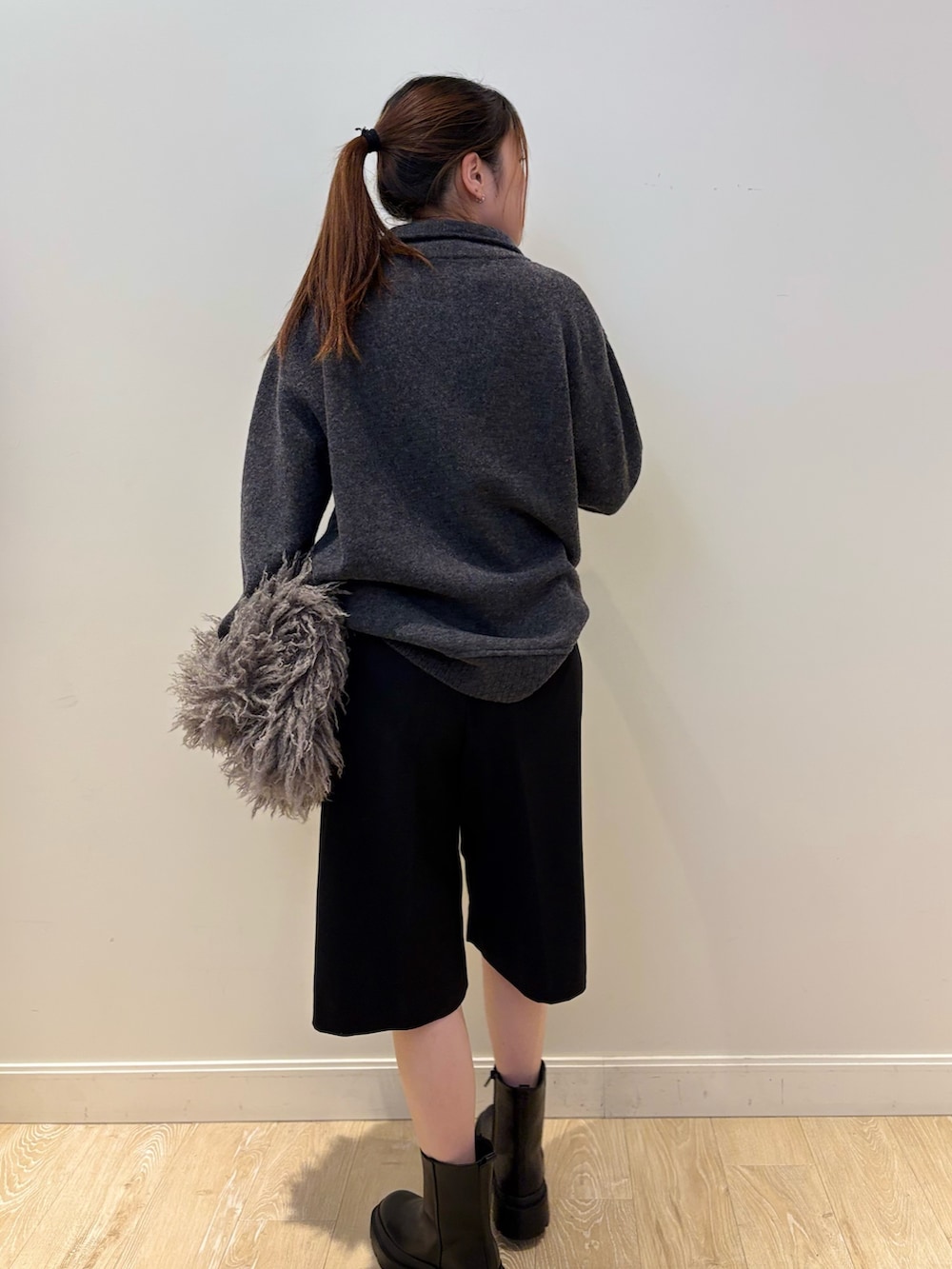 ベージュ系のショルダーバッグ、ブラック系のブーツ、ブラック系のその他パンツを着用したレディースの冬コーディネートの2枚目の写真