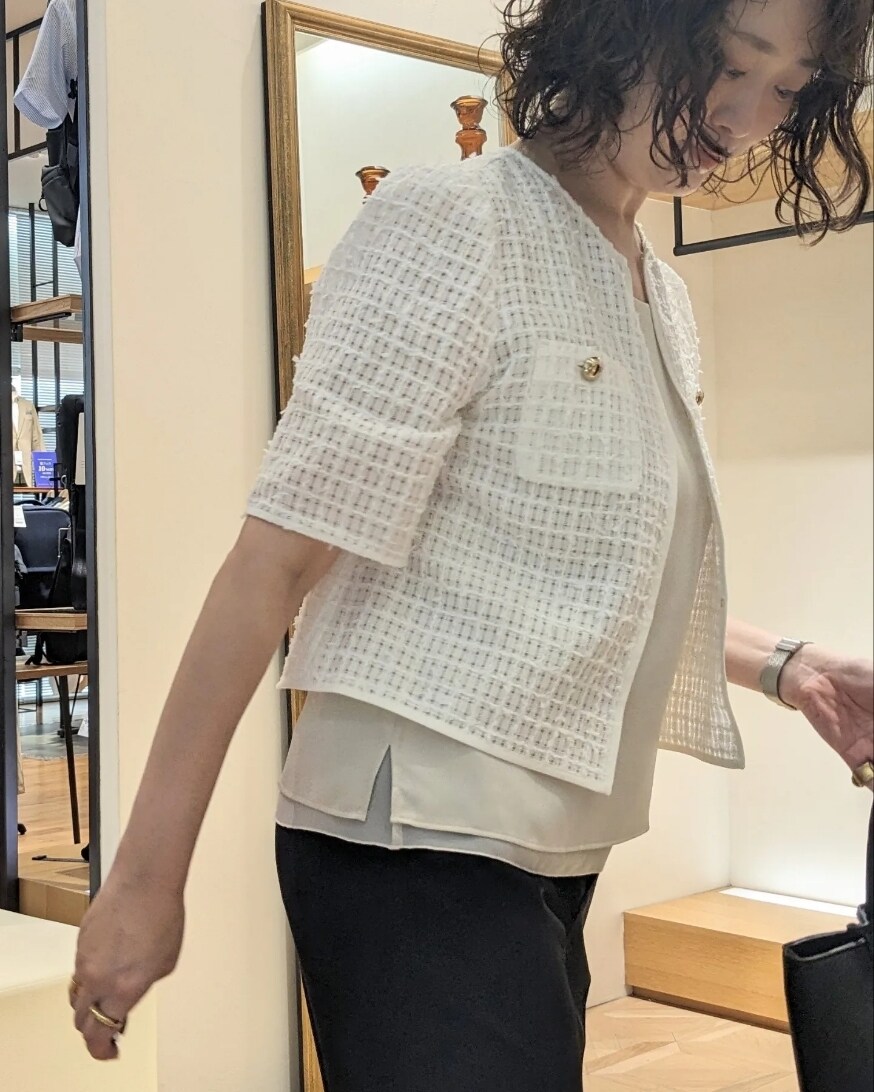 ホワイト系のノーカラージャケット、ブラック系のトートバッグ、ブラック系のその他パンツを着用したレディースの夏コーディネートの3枚目の写真