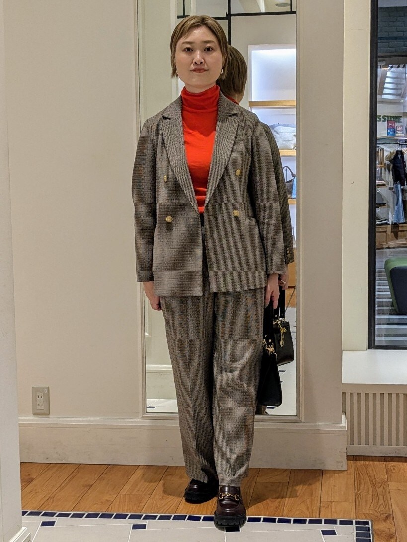ベージュ系のテーラードジャケット、オレンジ系のニット/セーター、ブラウン系のその他パンツを着用したレディースの冬コーディネートの3枚目の写真