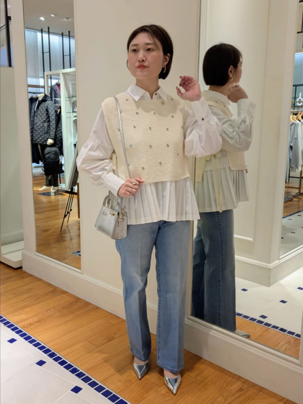 ホワイト系のシャツ/ブラウス、ホワイト系のベスト、シルバー系のショルダーバッグを着用したレディースの冬コーディネートの8枚目の写真