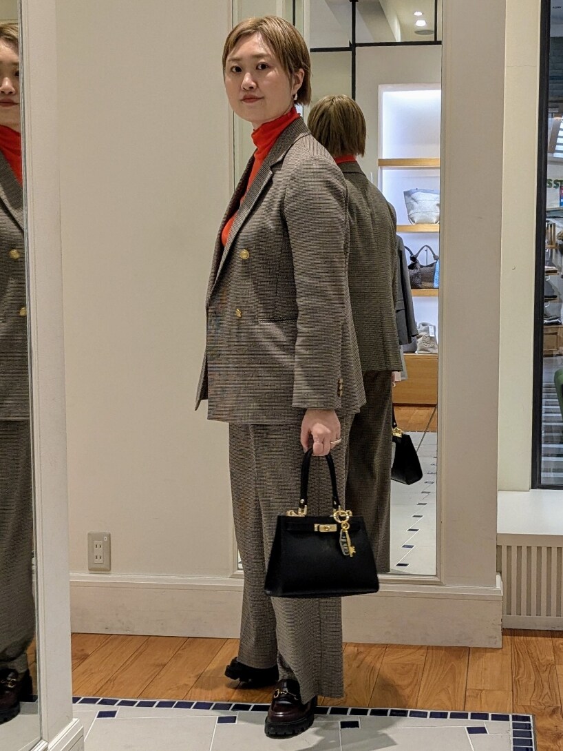 ベージュ系のテーラードジャケット、オレンジ系のニット/セーター、ブラウン系のその他パンツを着用したレディースの冬コーディネートの7枚目の写真