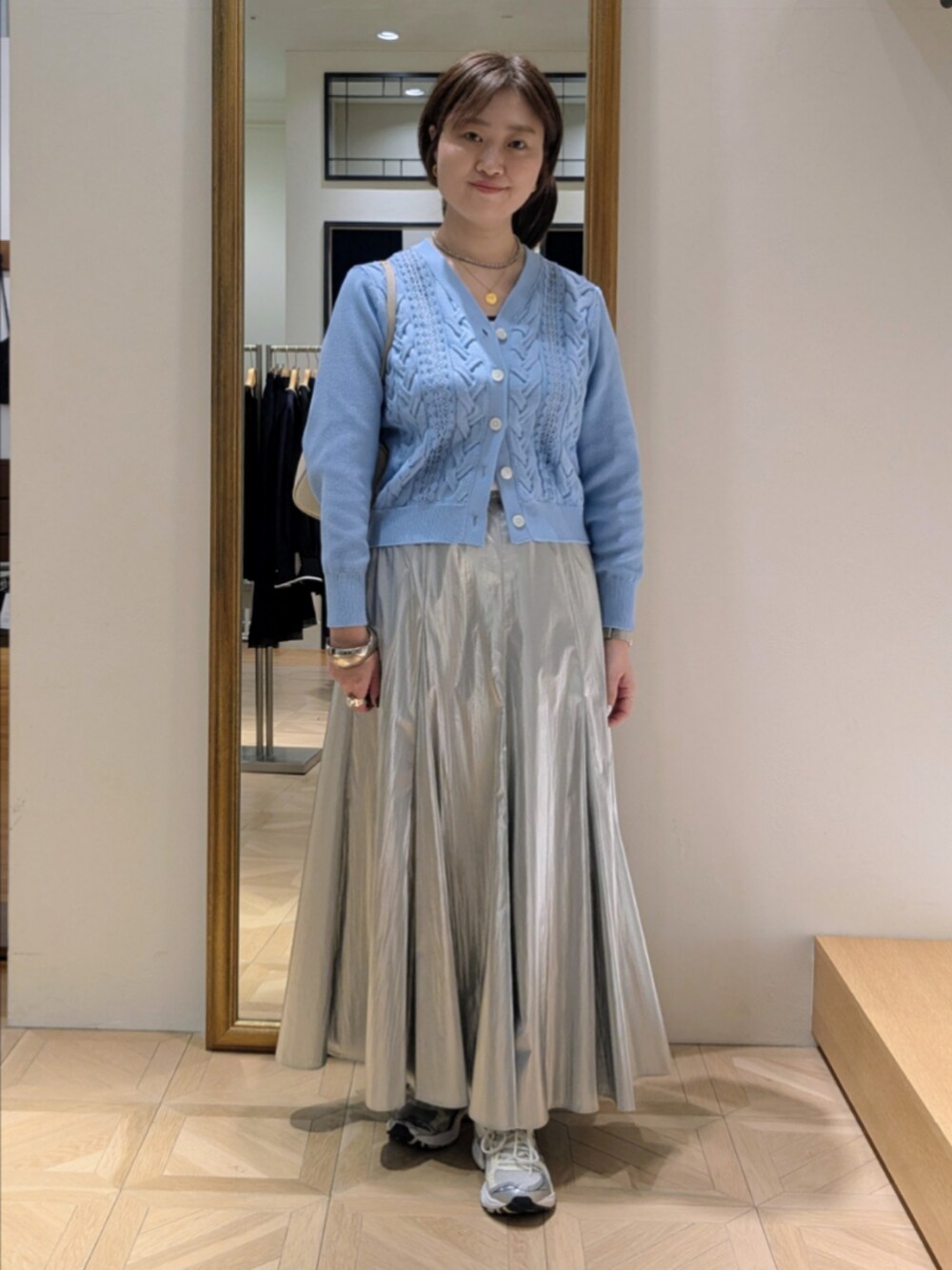 シルバー系のスカート、ブルー系のカーディガン/ボレロ、グリーン系のトレンチコートを着用したレディースの冬コーディネートの7枚目の写真