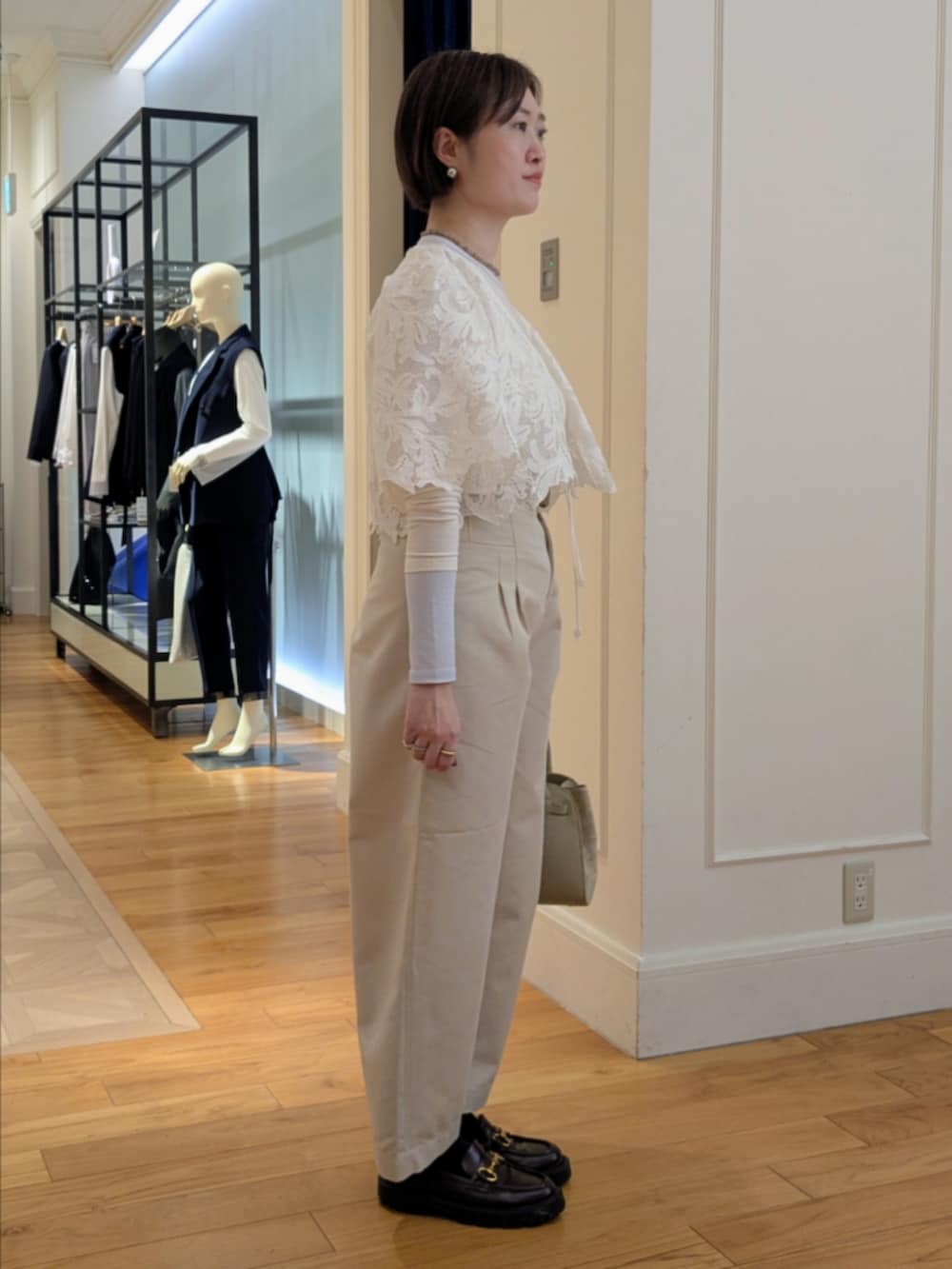 ベージュ系のトートバッグ、グレー系のネックレス、シルバー系のピアス（両耳用）を着用したレディースの冬コーディネートの5枚目の写真