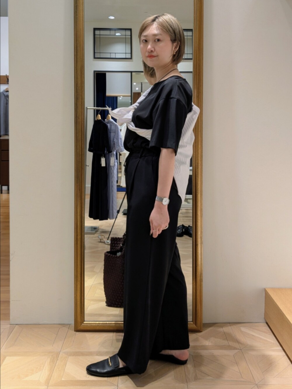 ブラウン系のトートバッグ、ブラック系のシャツ/ブラウス、ブラック系のその他パンツを着用したレディースの春コーディネートの6枚目の写真
