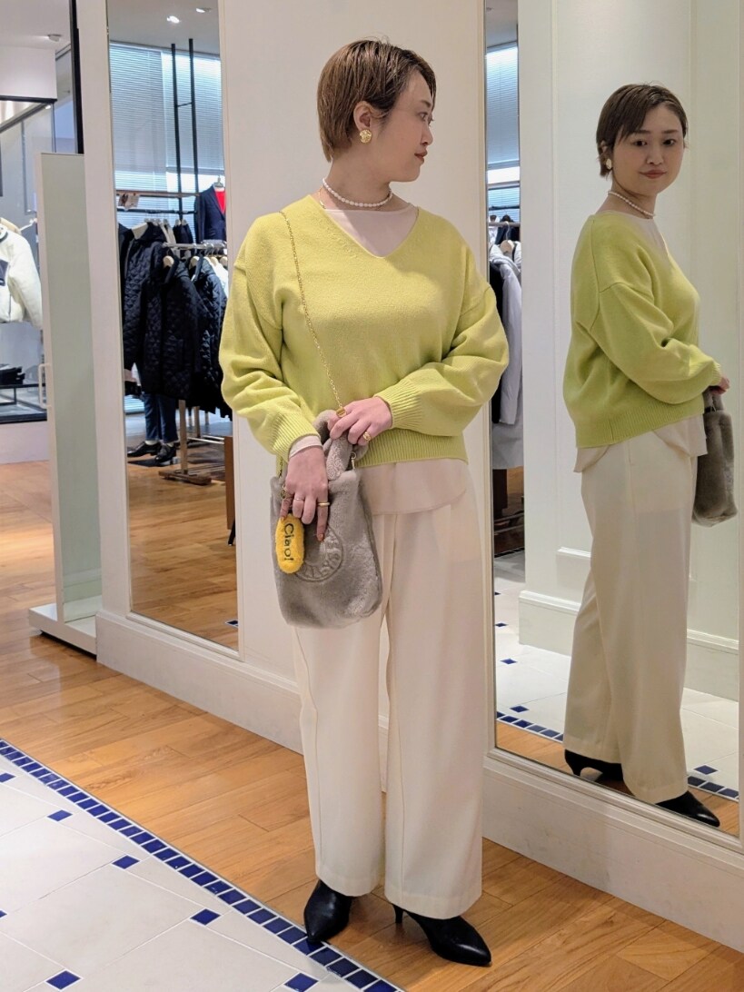 イエロー系のニット/セーター、ホワイト系のその他パンツ、ベージュ系のトートバッグを着用したレディースの冬コーディネートの2枚目の写真