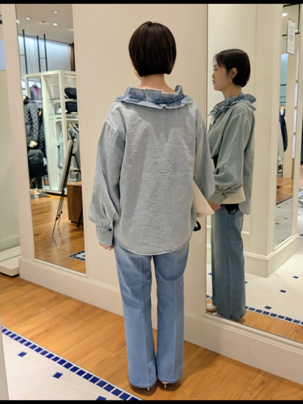 ブルー系のデニムパンツ、ブルー系のシャツ/ブラウス、ホワイト系のトートバッグを着用したレディースの冬コーディネートの6枚目の写真