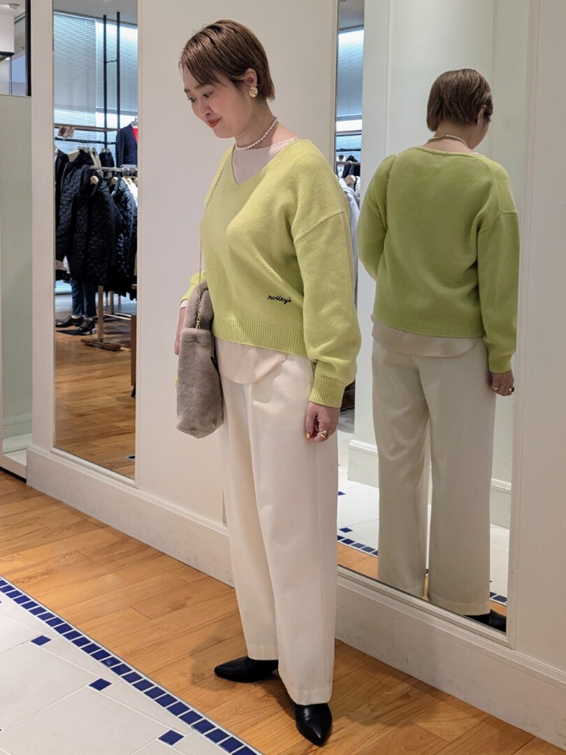 イエロー系のニット/セーター、ホワイト系のその他パンツ、ベージュ系のトートバッグを着用したレディースの冬コーディネートの7枚目の写真