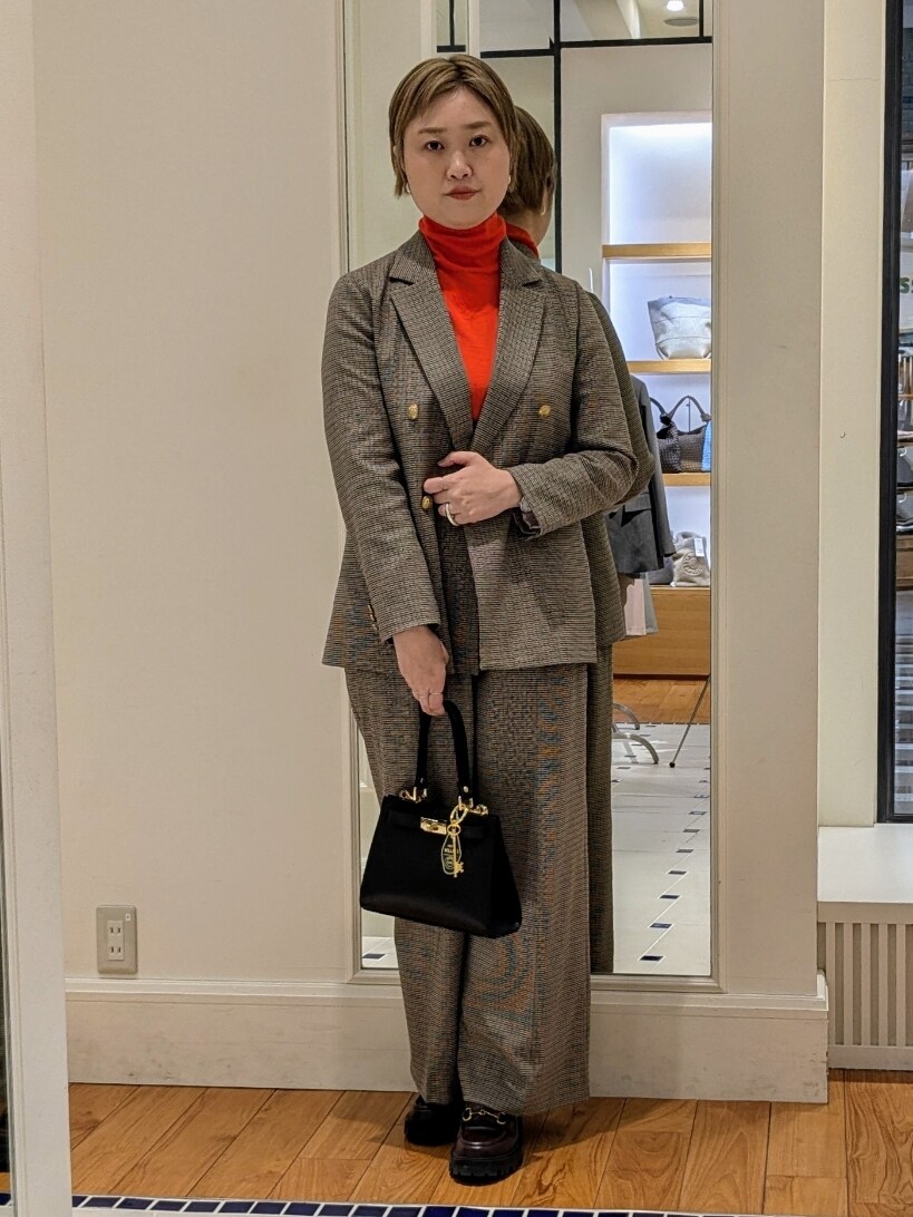 ベージュ系のテーラードジャケット、オレンジ系のニット/セーター、ブラウン系のその他パンツを着用したレディースの冬コーディネートの9枚目の写真