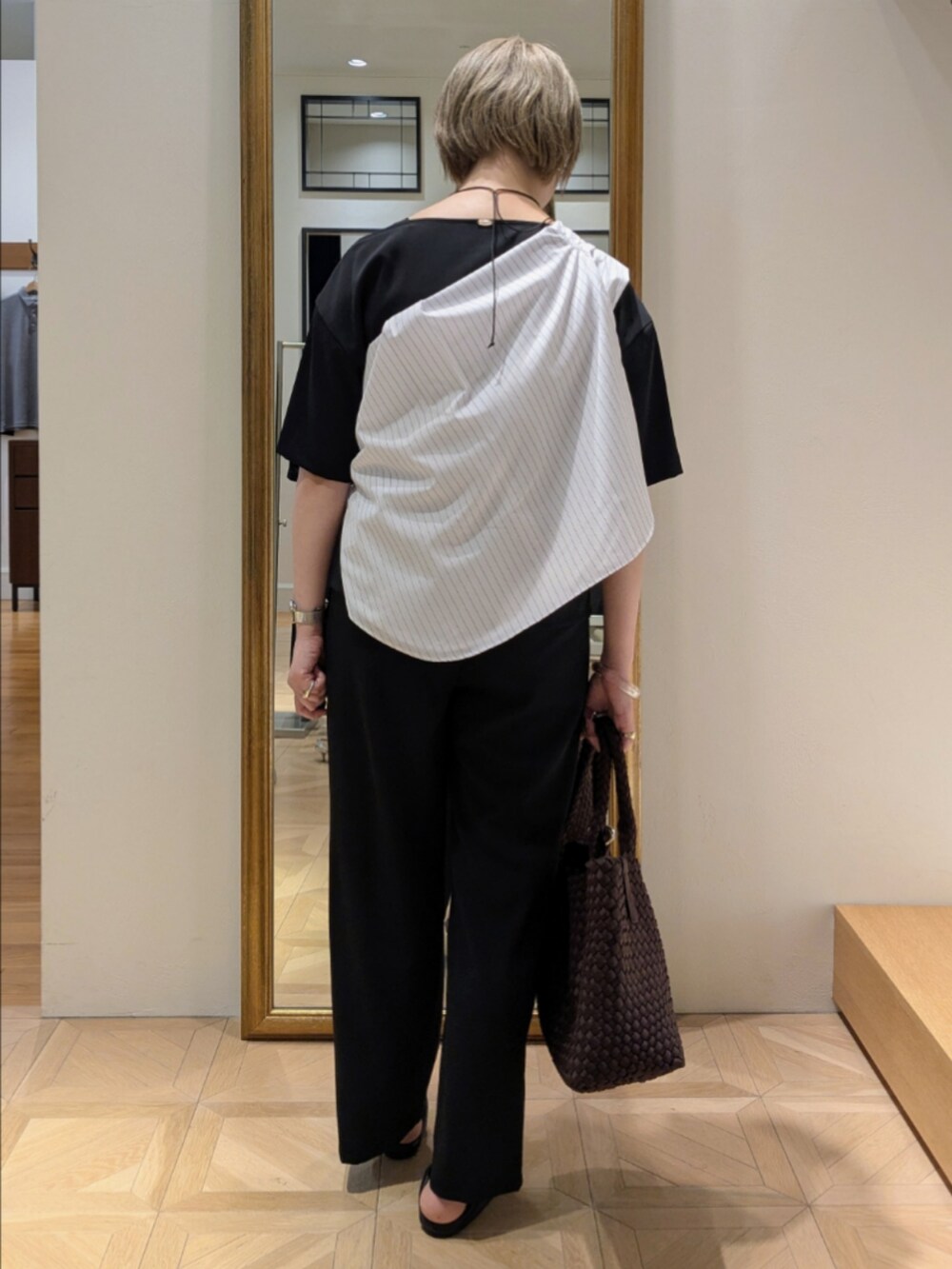 ブラウン系のトートバッグ、ブラック系のシャツ/ブラウス、ブラック系のその他パンツを着用したレディースの春コーディネートの7枚目の写真