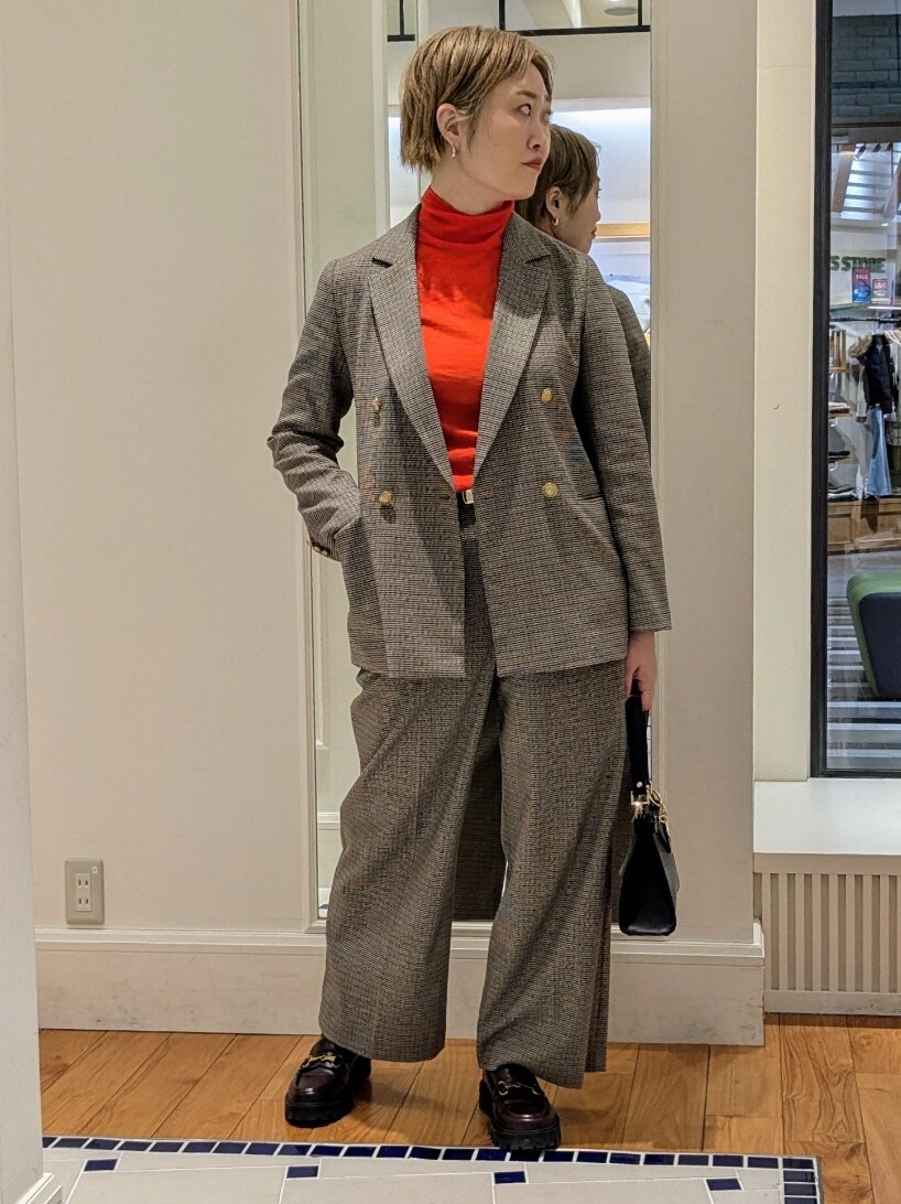 ベージュ系のテーラードジャケット、オレンジ系のニット/セーター、ブラウン系のその他パンツを着用したレディースの冬コーディネートの2枚目の写真