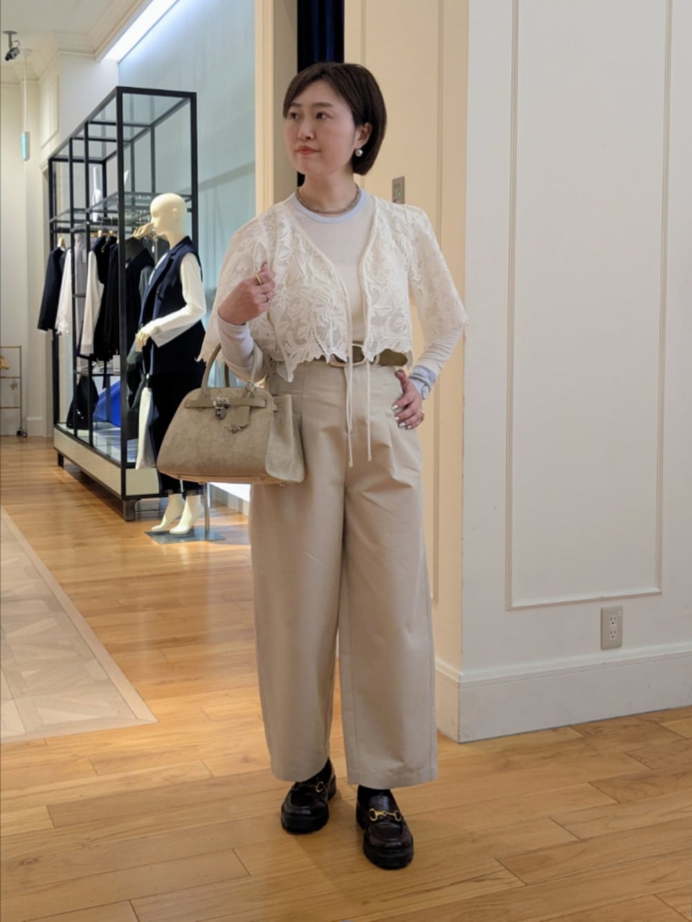 ベージュ系のトートバッグ、グレー系のネックレス、シルバー系のピアス（両耳用）を着用したレディースの冬コーディネートの6枚目の写真