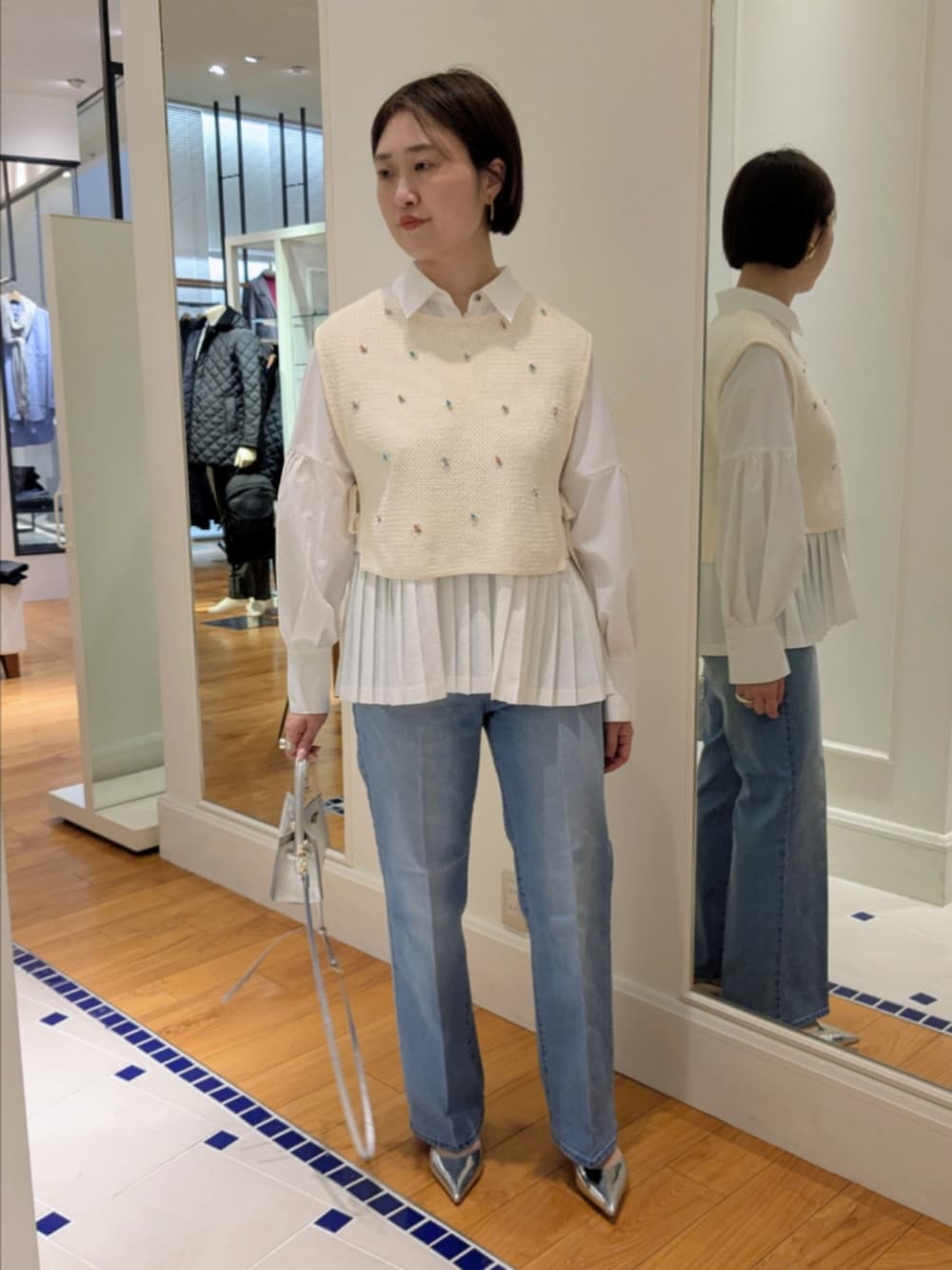 ホワイト系のシャツ/ブラウス、ホワイト系のベスト、シルバー系のショルダーバッグを着用したレディースの冬コーディネートの10枚目の写真