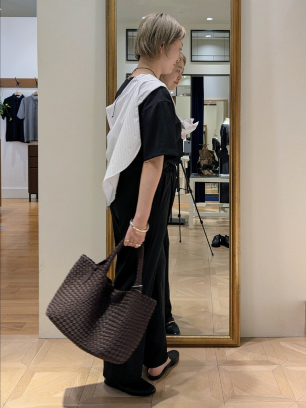 ブラウン系のトートバッグ、ブラック系のシャツ/ブラウス、ブラック系のその他パンツを着用したレディースの春コーディネートの8枚目の写真