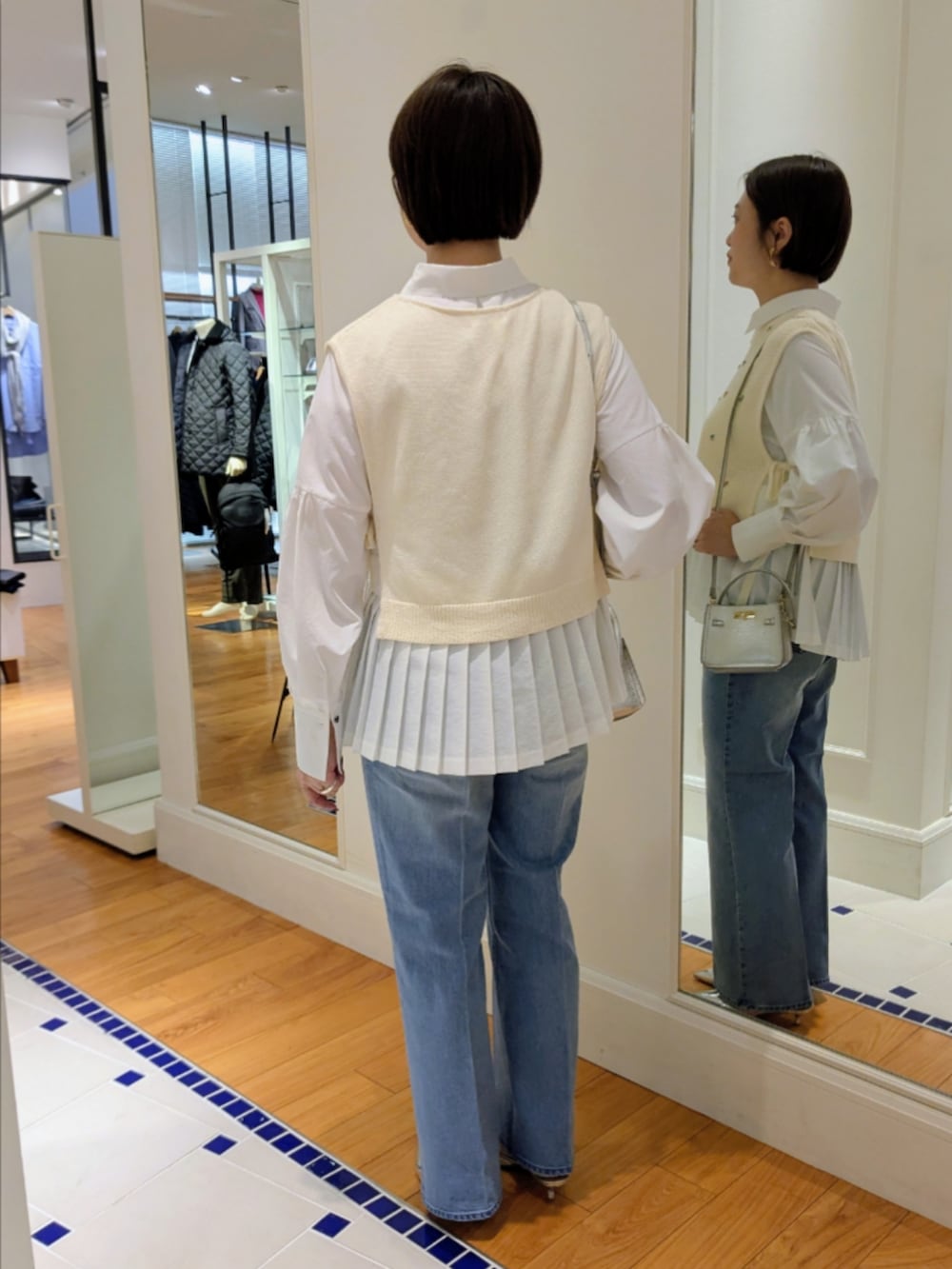 ホワイト系のシャツ/ブラウス、ホワイト系のベスト、シルバー系のショルダーバッグを着用したレディースの冬コーディネートの5枚目の写真