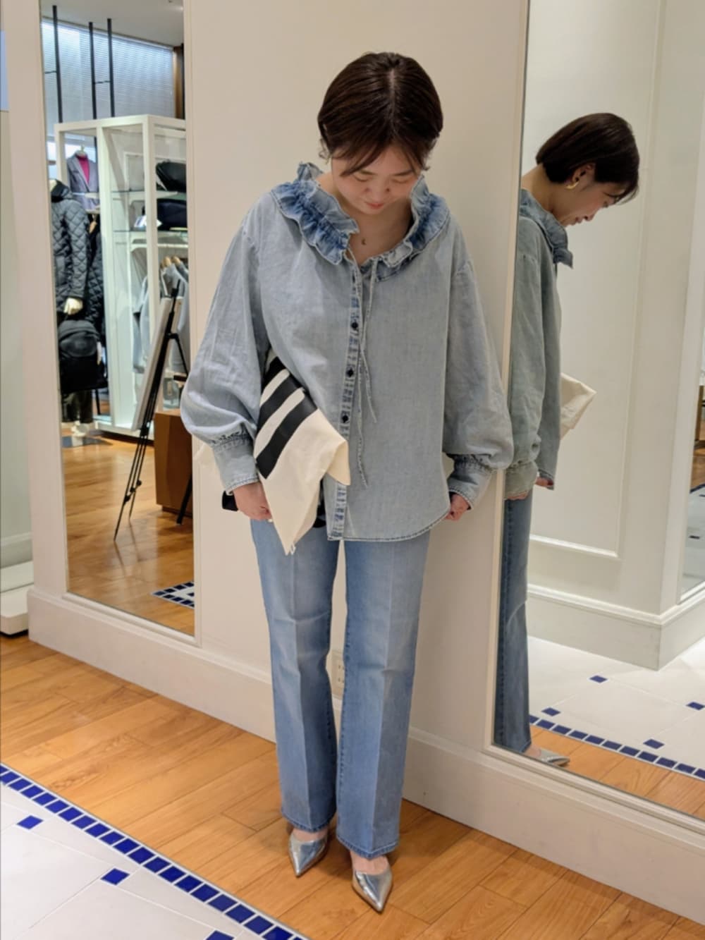 ブルー系のデニムパンツ、ブルー系のシャツ/ブラウス、ホワイト系のトートバッグを着用したレディースの冬コーディネートの10枚目の写真