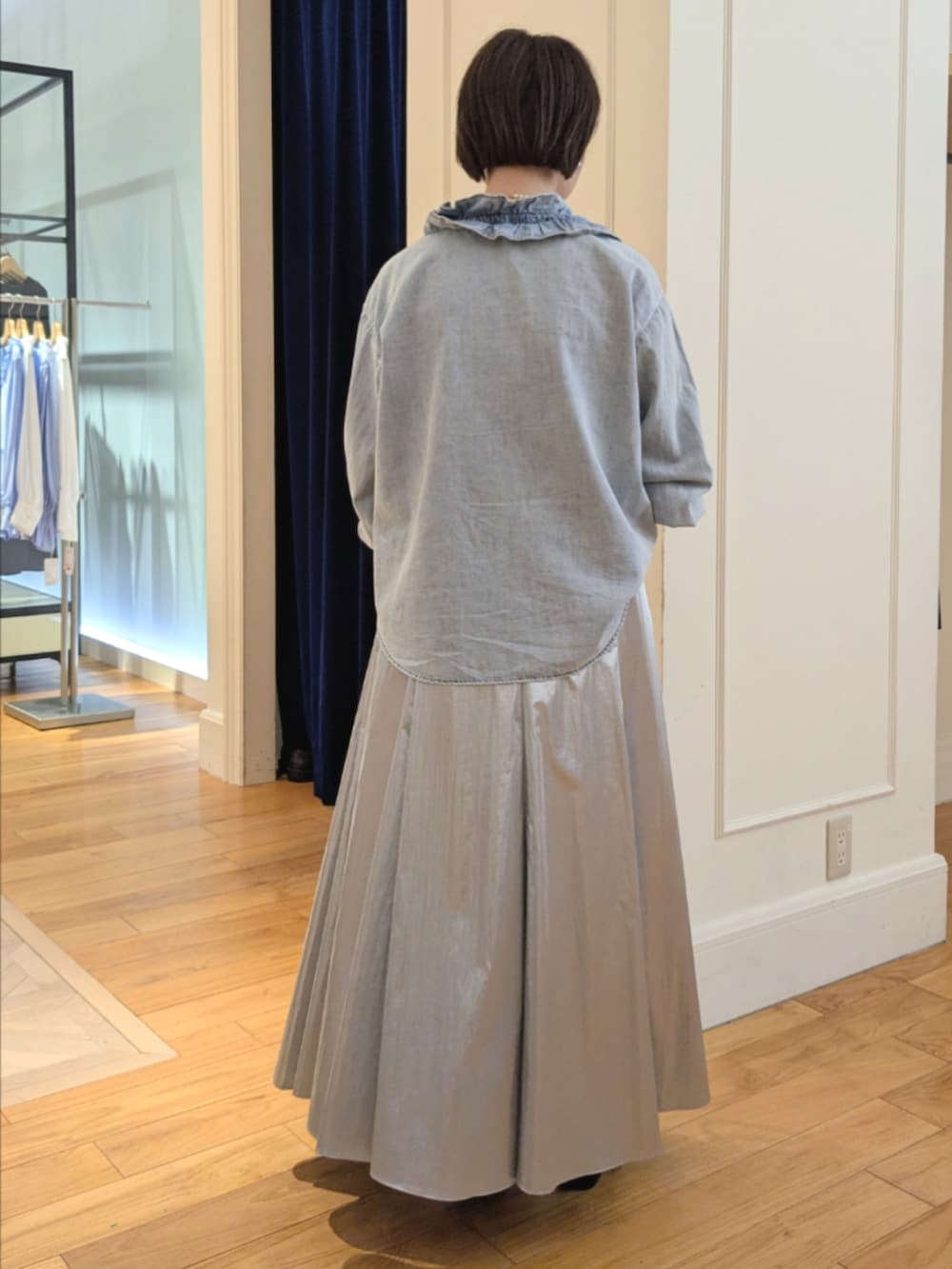 シルバー系のスカート、ブルー系のシャツ/ブラウス、ブラック系のショルダーバッグを着用したレディースの冬コーディネートの8枚目の写真