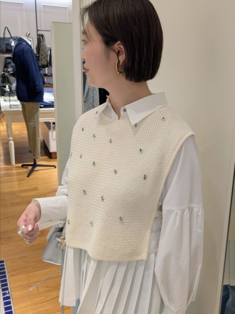 ホワイト系のシャツ/ブラウス、ホワイト系のベスト、シルバー系のショルダーバッグを着用したレディースの冬コーディネートの3枚目の写真