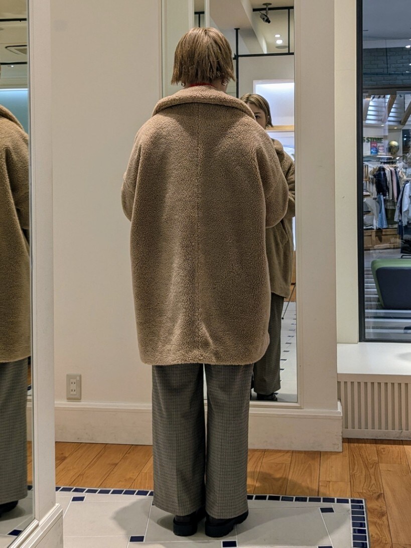 イエロー系のダッフルコート、オレンジ系のニット/セーター、ブラウン系のその他パンツを着用したレディースの冬コーディネートの6枚目の写真