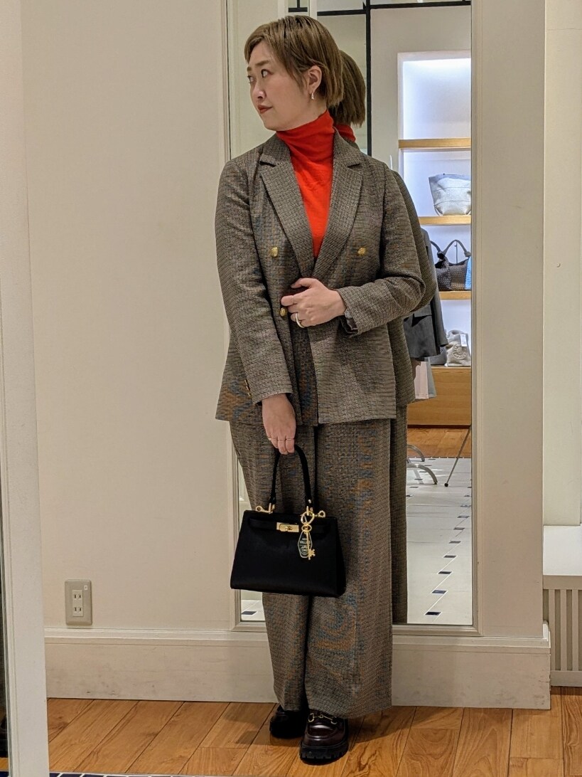 ベージュ系のテーラードジャケット、オレンジ系のニット/セーター、ブラウン系のその他パンツを着用したレディースの冬コーディネートの8枚目の写真