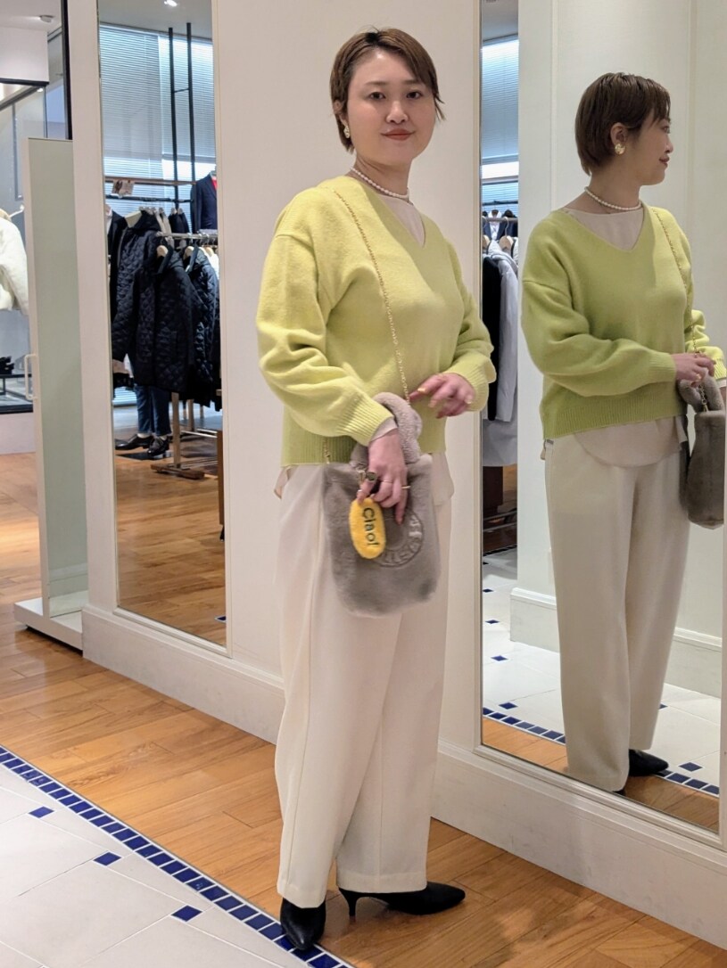 イエロー系のニット/セーター、ホワイト系のその他パンツ、ベージュ系のトートバッグを着用したレディースの冬コーディネートの5枚目の写真