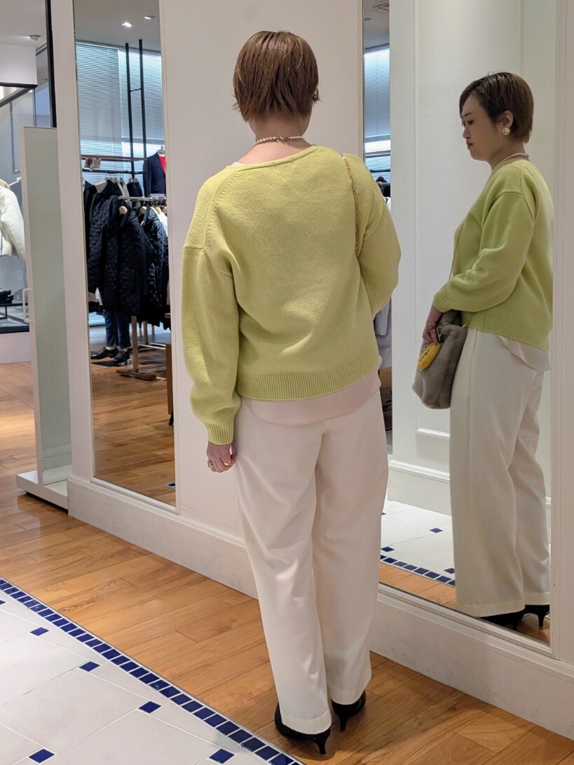 イエロー系のニット/セーター、ホワイト系のその他パンツ、ベージュ系のトートバッグを着用したレディースの冬コーディネートの6枚目の写真