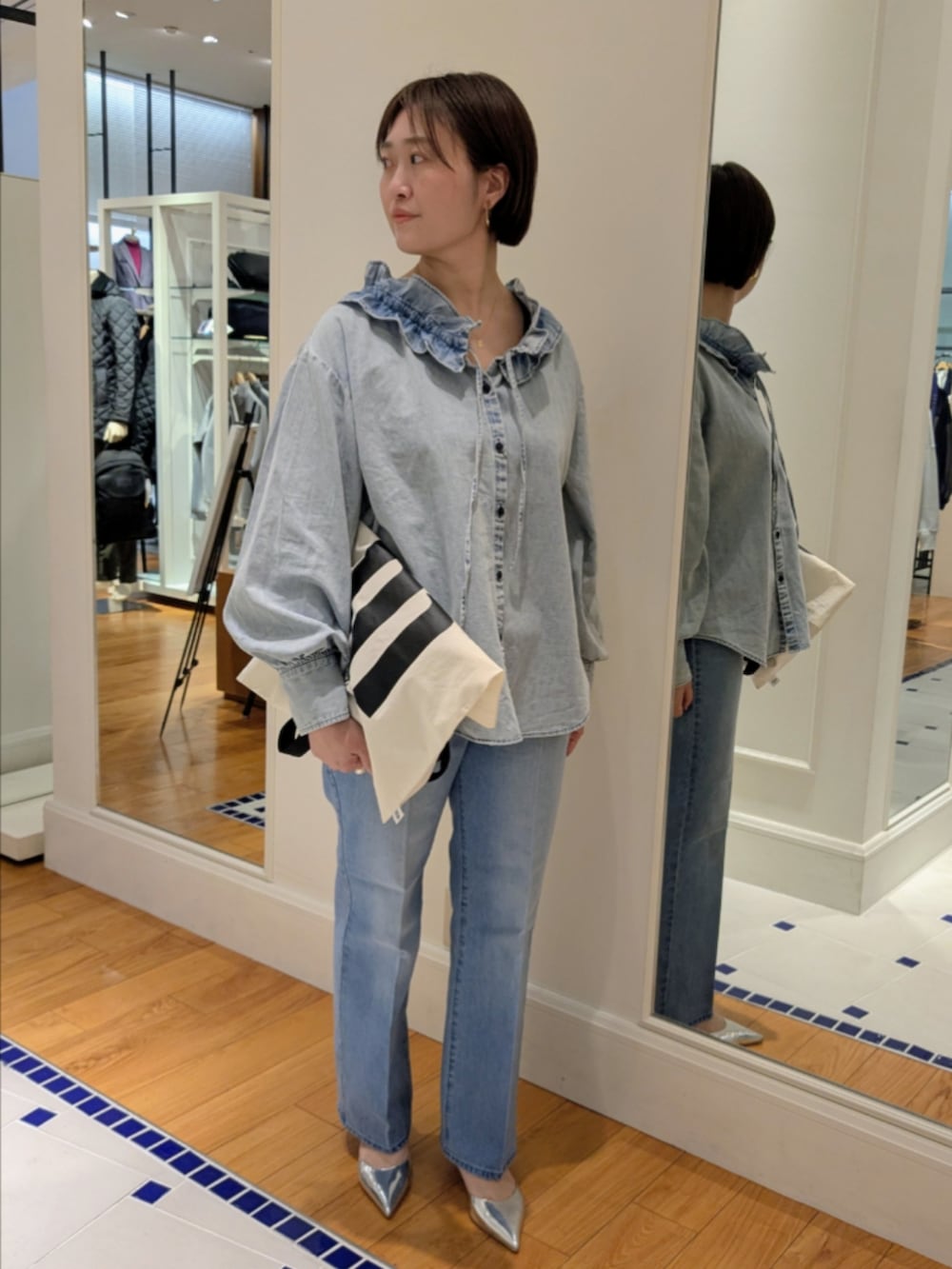 ブルー系のデニムパンツ、ブルー系のシャツ/ブラウス、ホワイト系のトートバッグを着用したレディースの冬コーディネートの9枚目の写真