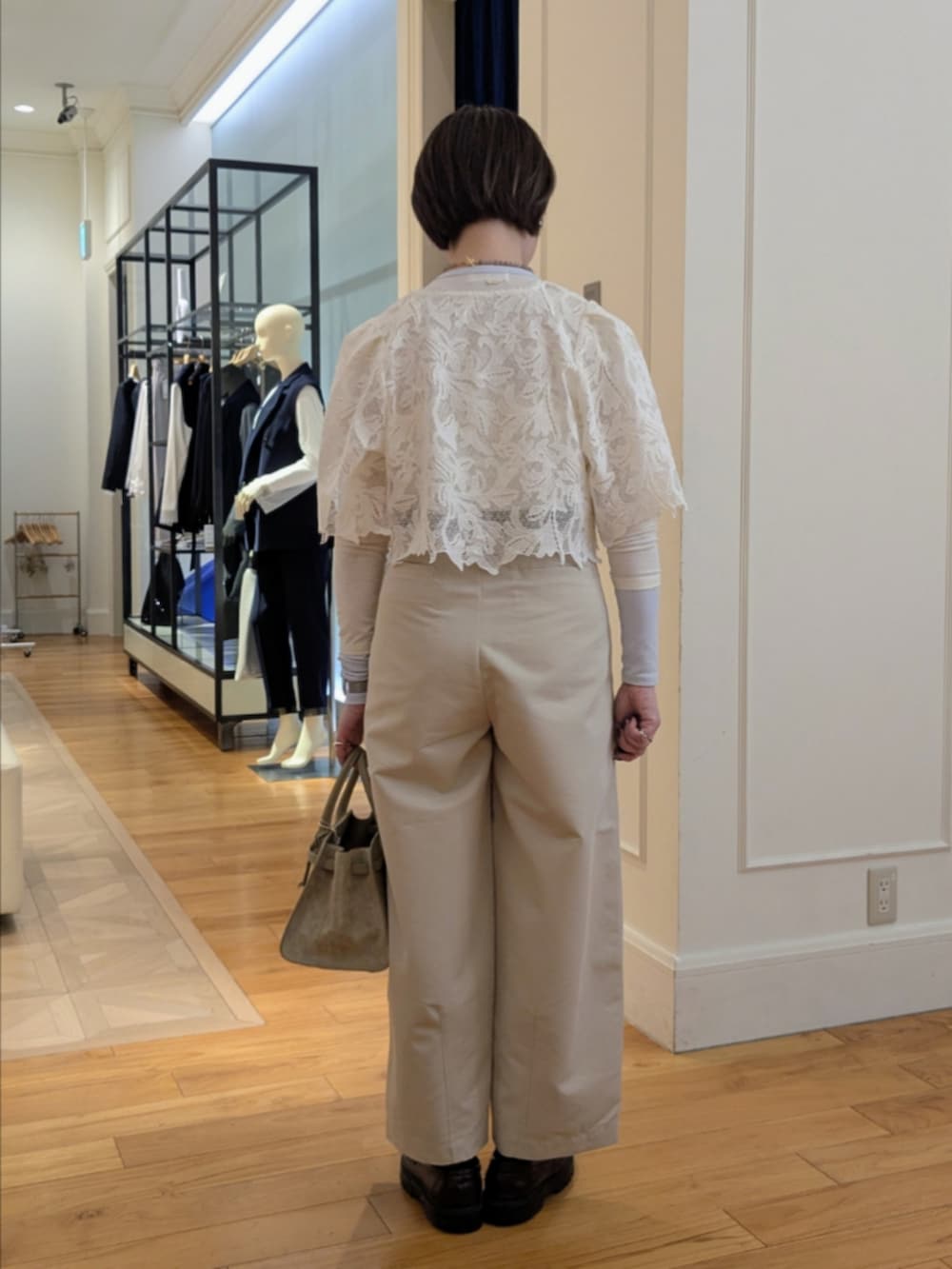 ベージュ系のトートバッグ、グレー系のネックレス、シルバー系のピアス（両耳用）を着用したレディースの冬コーディネートの3枚目の写真