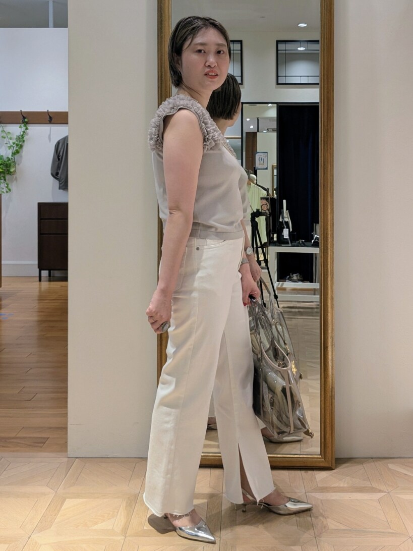 ベージュ系のニット/セーター、ホワイト系のデニムパンツ、ベージュ系のトートバッグを着用したレディースの夏コーディネートの4枚目の写真