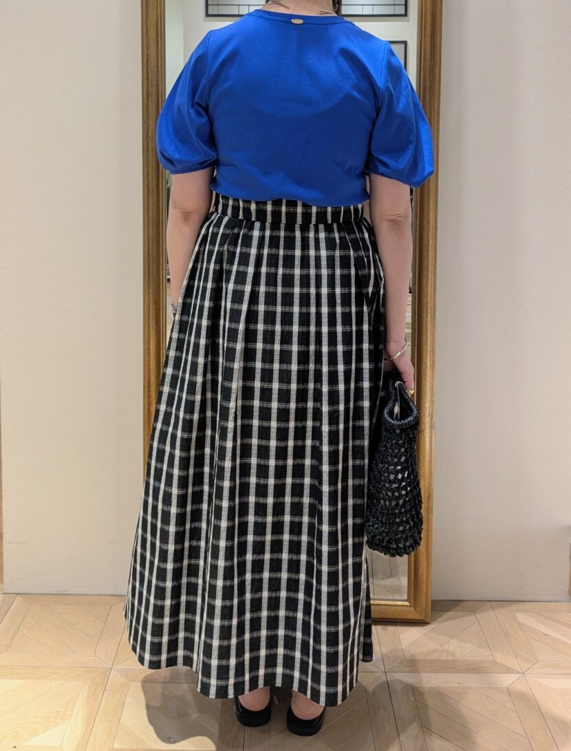 ブラック系のかごバッグ、ブラック系のスカート、ブルー系のTシャツ/カットソーを着用したレディースの春コーディネートの6枚目の写真